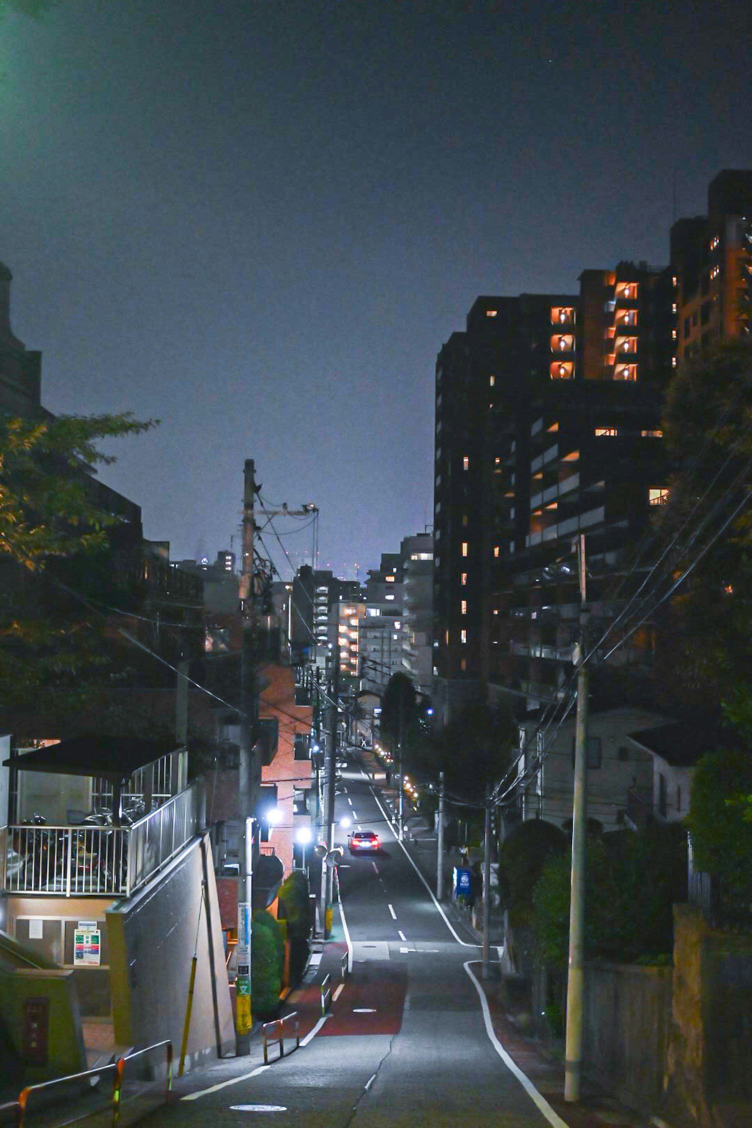 Quiet street scene at night with city buildings illuminated