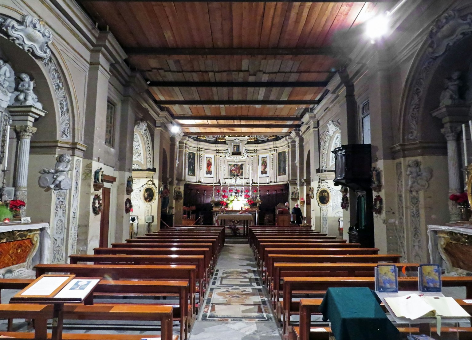 Interior gereja dengan bangku kayu dan ukiran dinding dekoratif