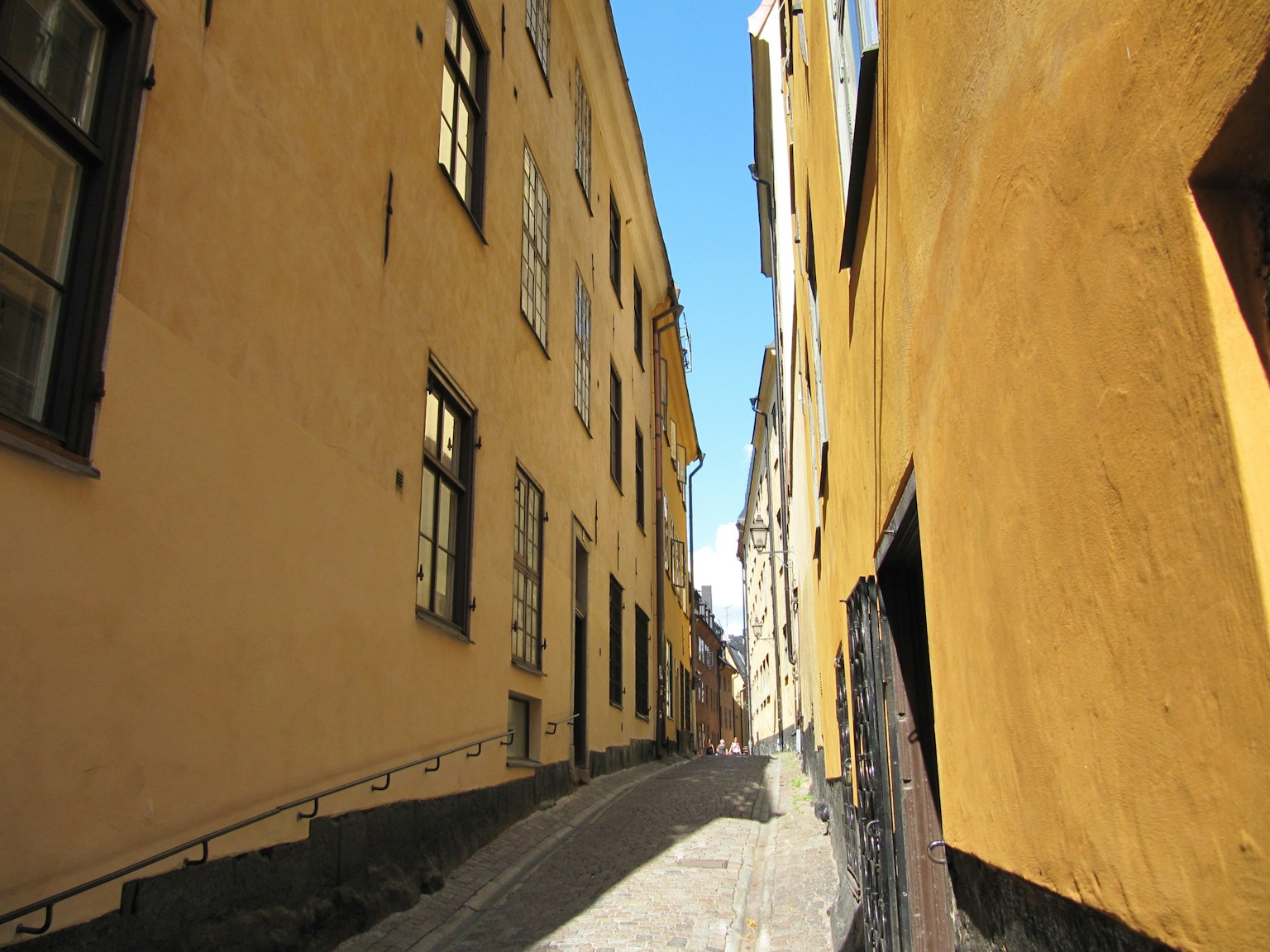 Narrow alley with yellow buildings and blue sky