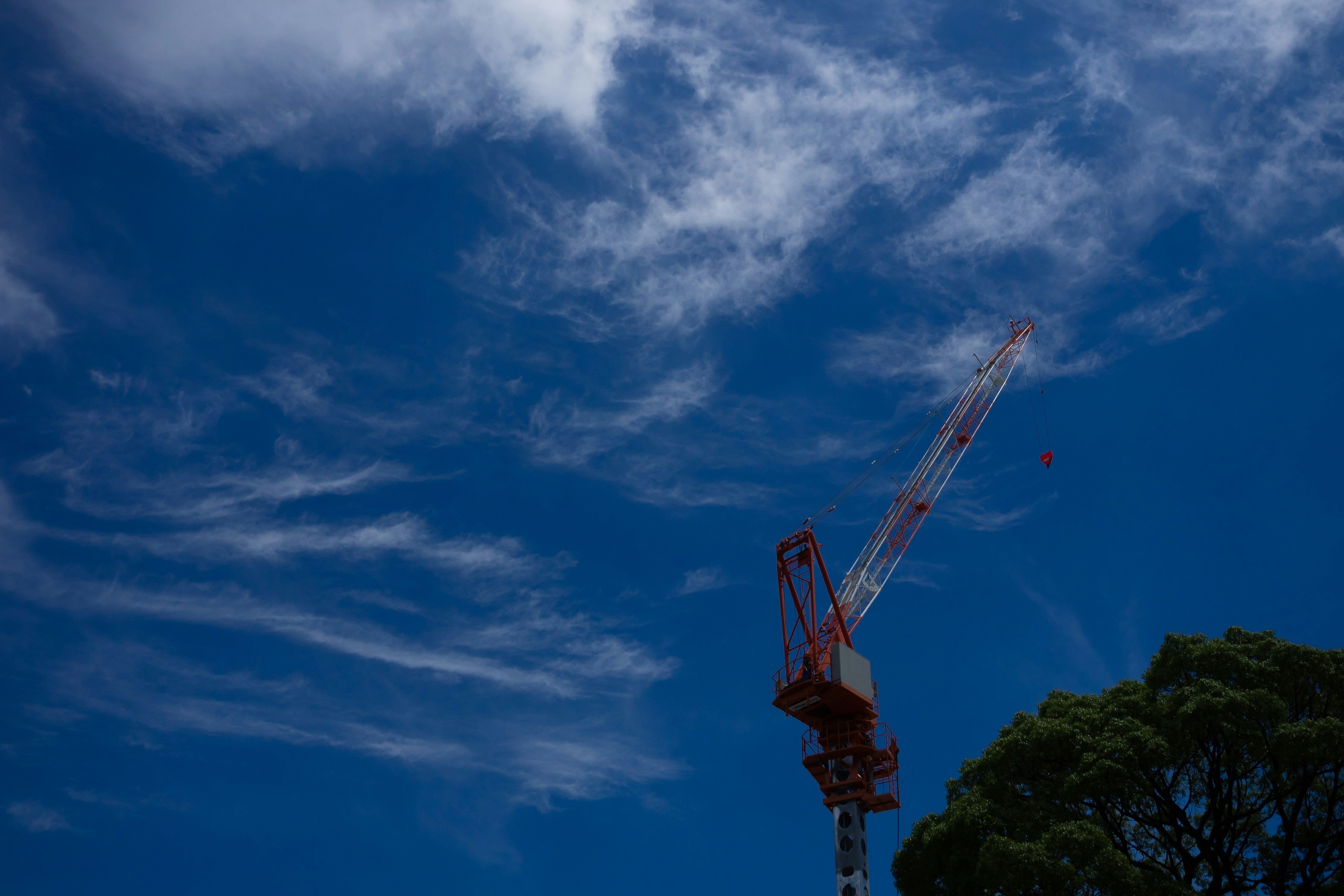 Kranarm und Maschinen vor blauem Himmel