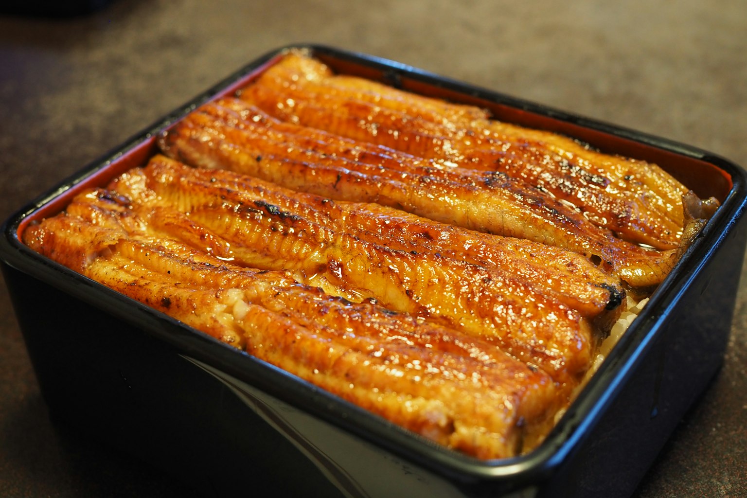 美味的鰻鱼饭装在黑色容器中