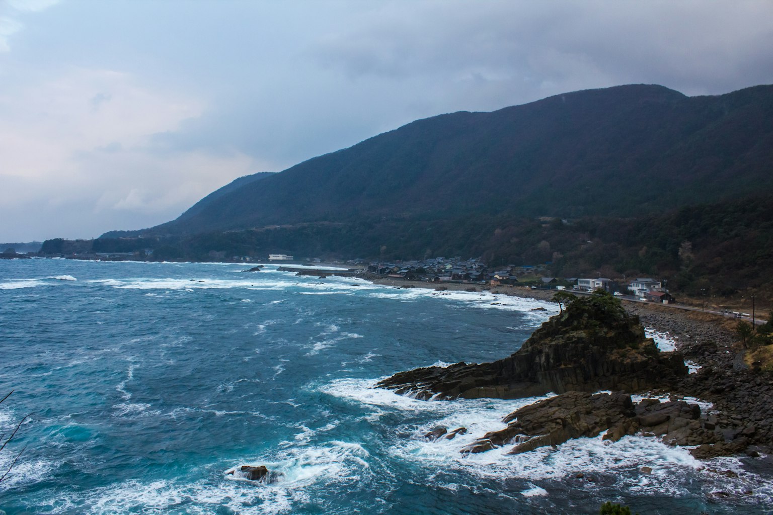 海岸风景背景有山波浪拍打岩石阴天