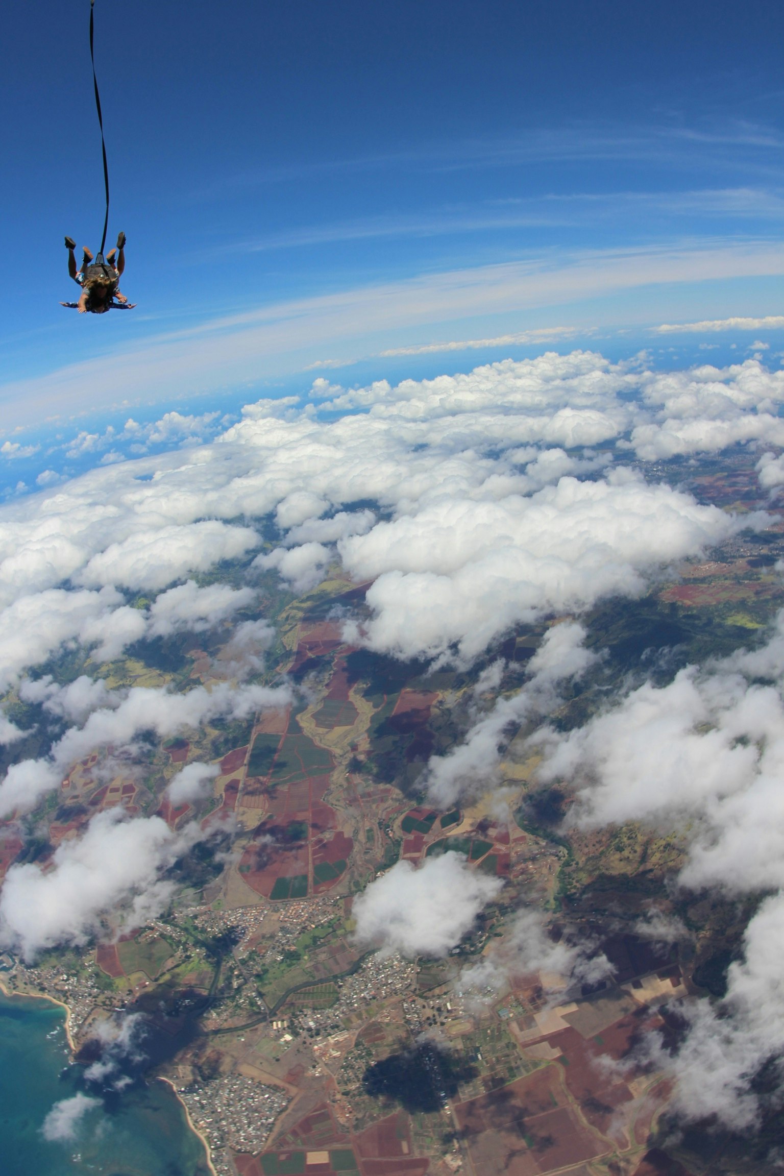 Pandangan udara seorang yang melakukan paralayang di atas awan dan pemandangan