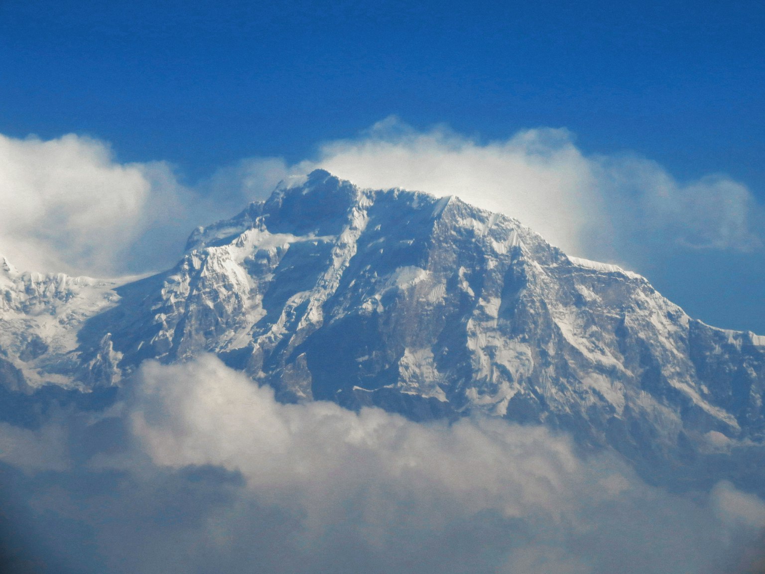 Puncak gunung bersalju di latar belakang langit biru yang cerah