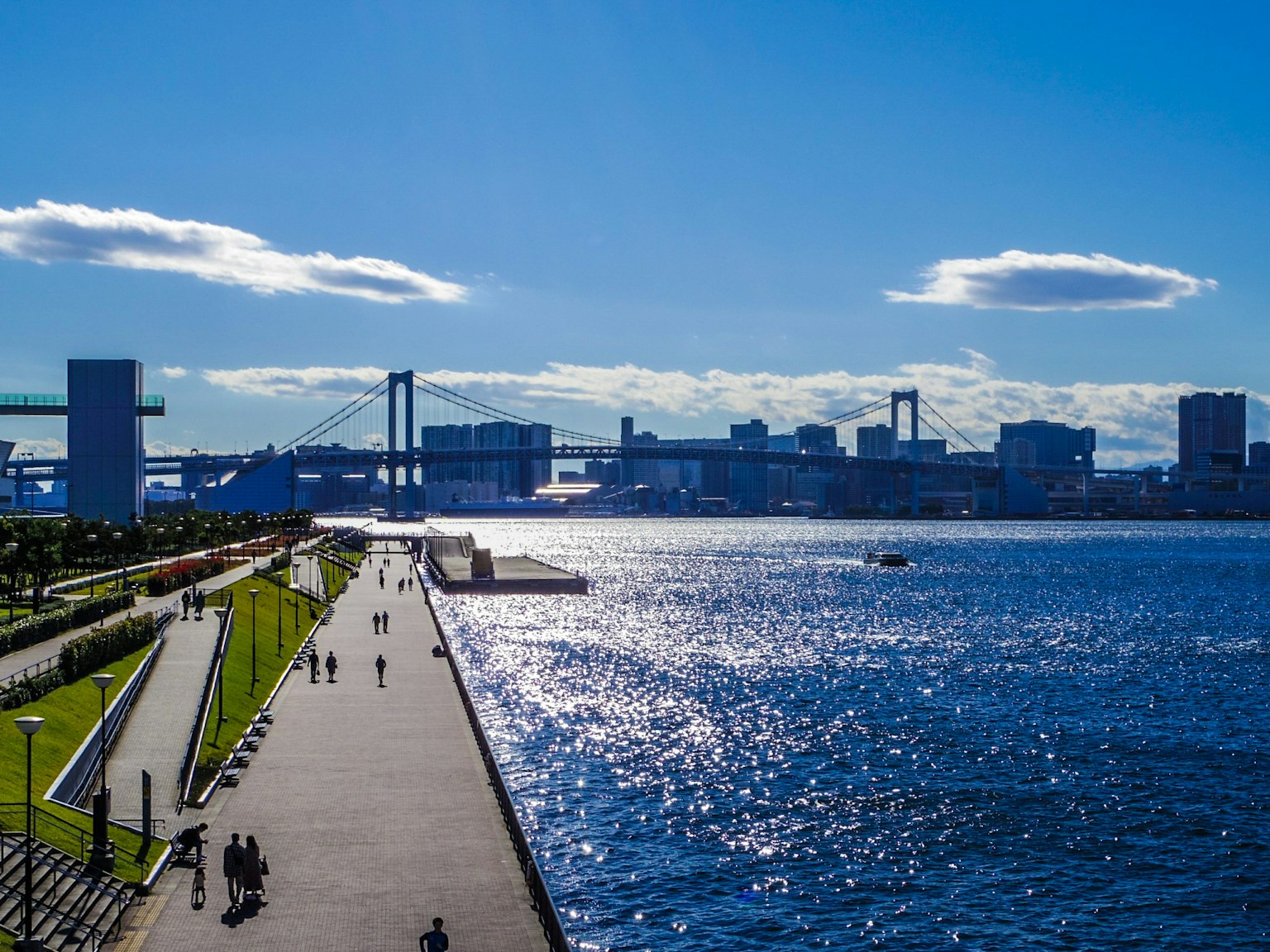 Paysage urbain avec ciel bleu et eau présentant des personnes marchant