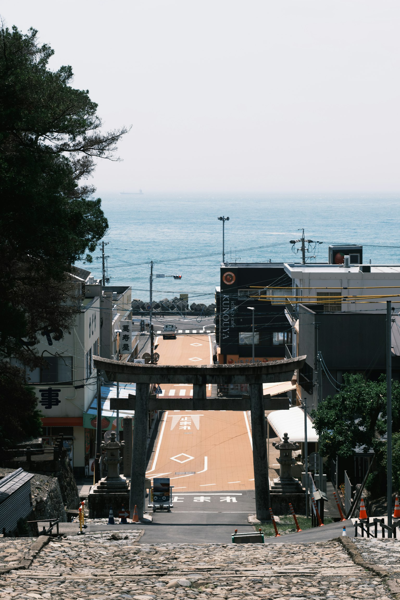 Vista di una città costiera con un torii e una strada