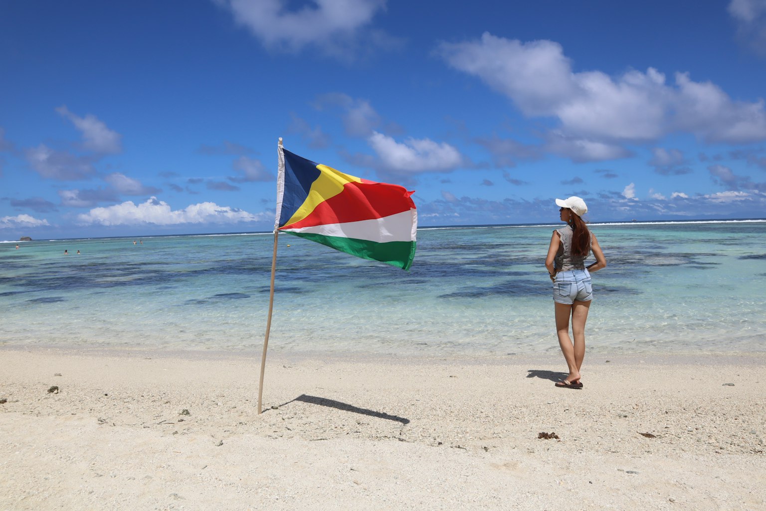 Người phụ nữ ngắm biển trên bãi biển với cờ Nam Sudan