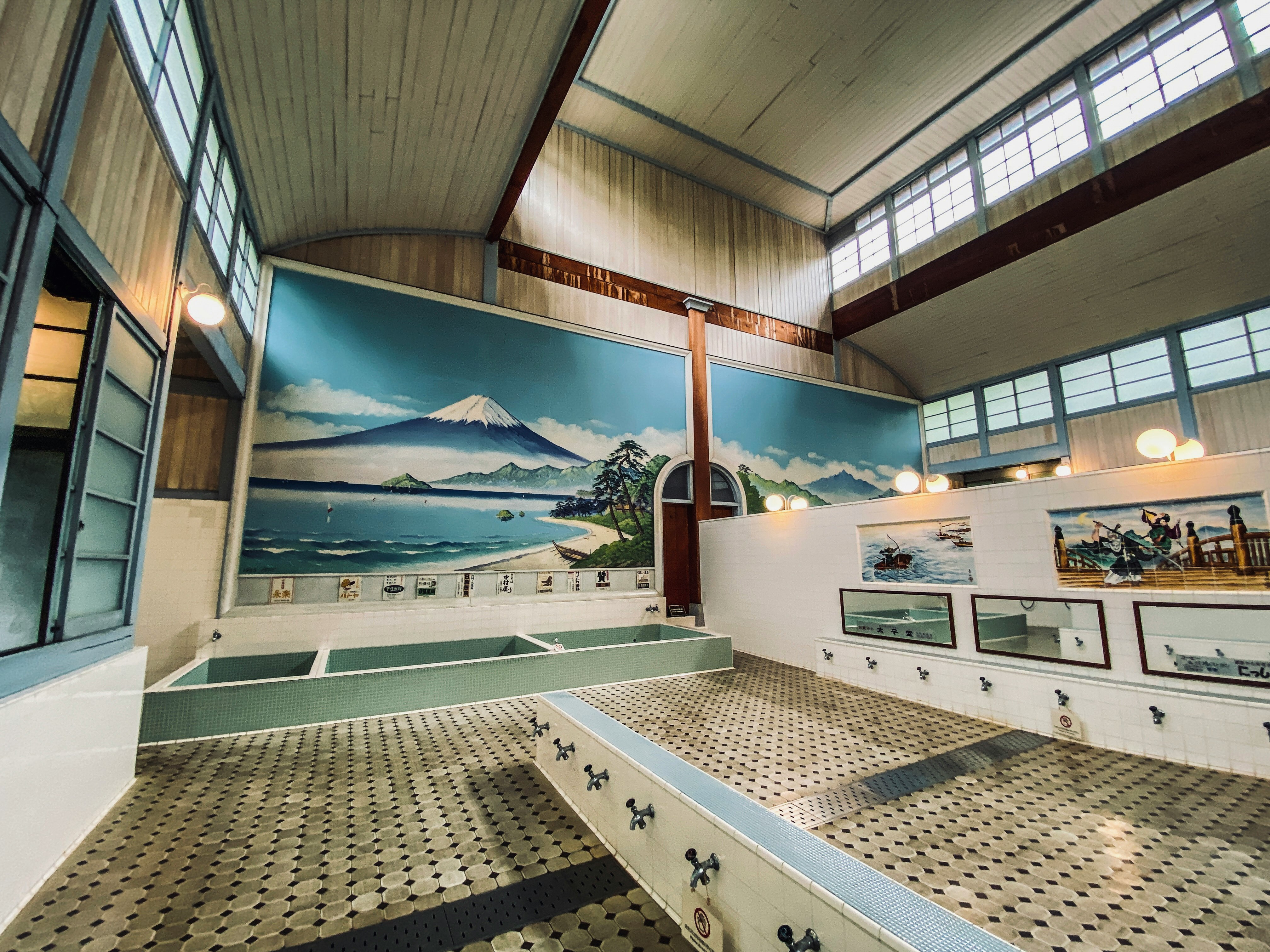 zona de baño tipo onsen en interior con un mural del monte Fuji