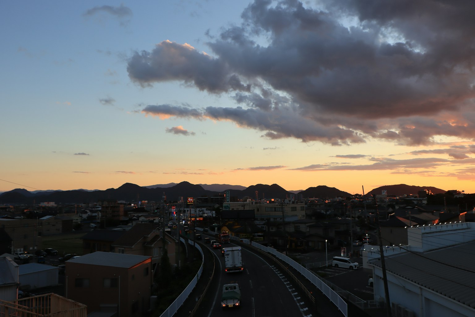 城市風景，夕陽天空和背景的山脈