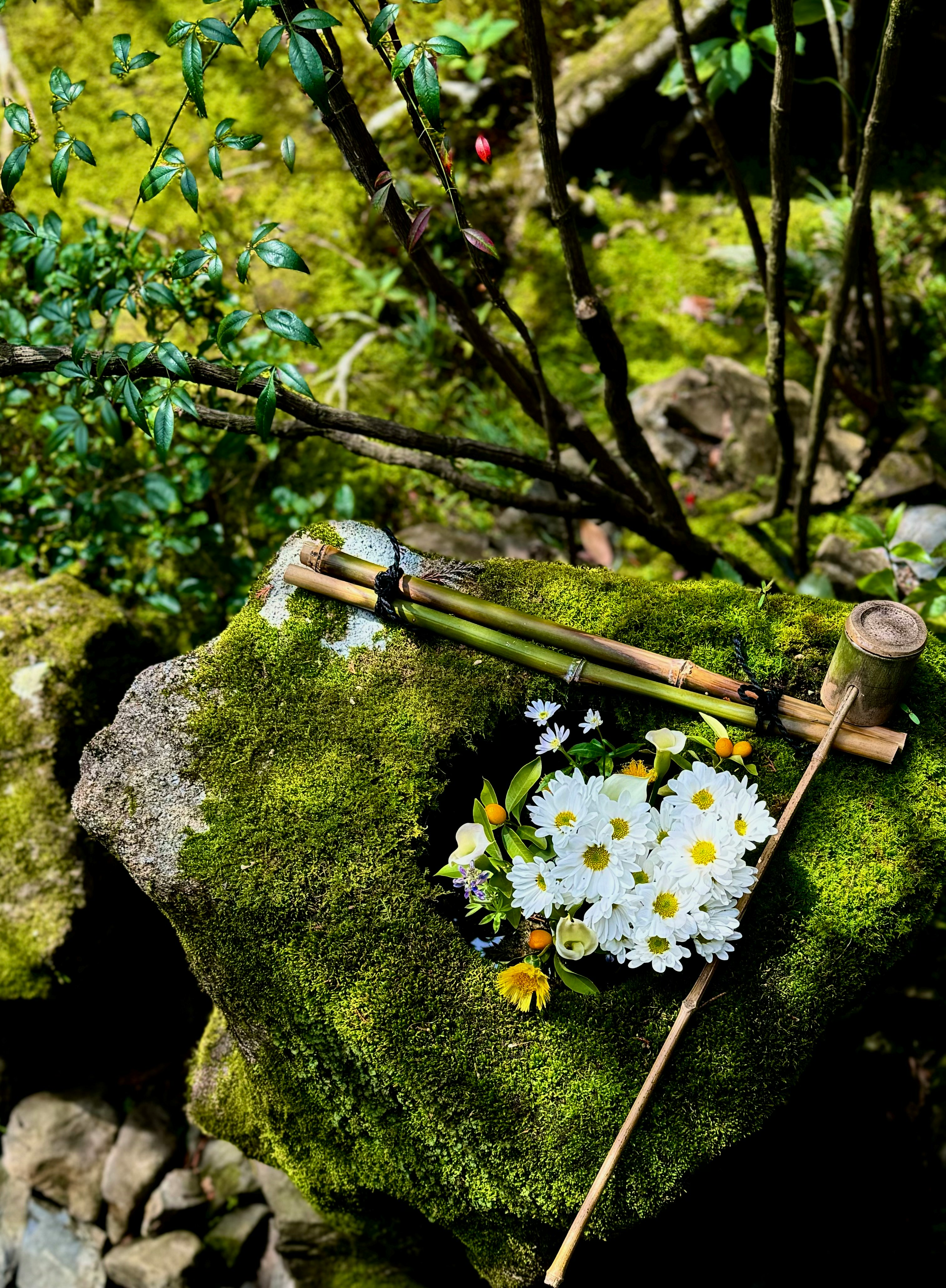 苔の上に置かれた花束と照らされた花の小さな飾り