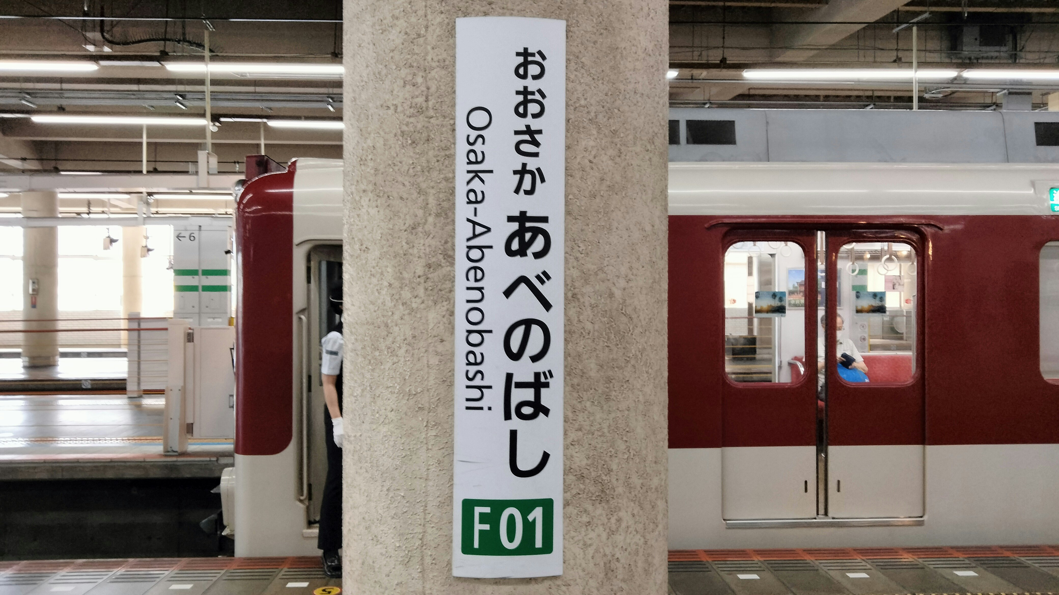 車站月台的列車與柱子上的標牌「おつかい あべのばし」