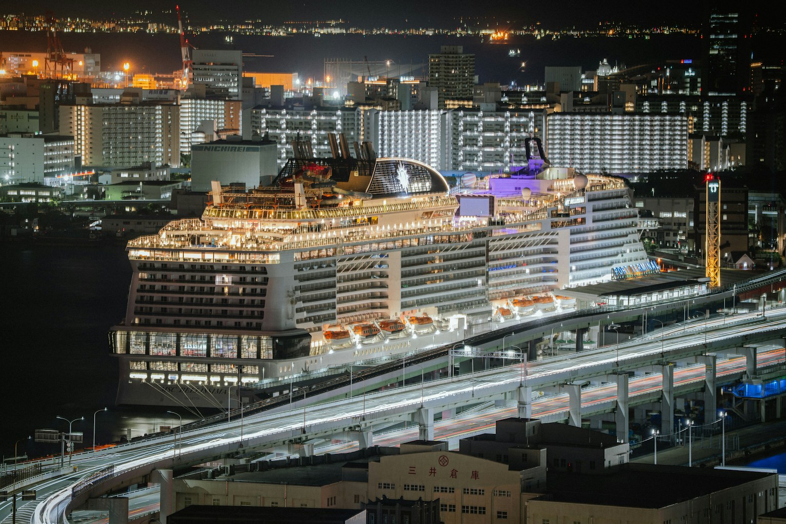 夜間停靠的豪華郵輪與背景城市燈光