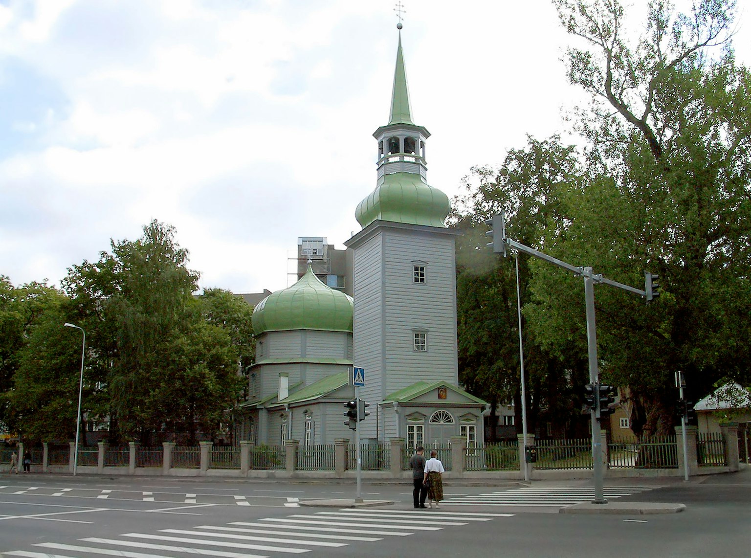 Kirche mit grünen Kuppeln und einem Turm an einer Kreuzung