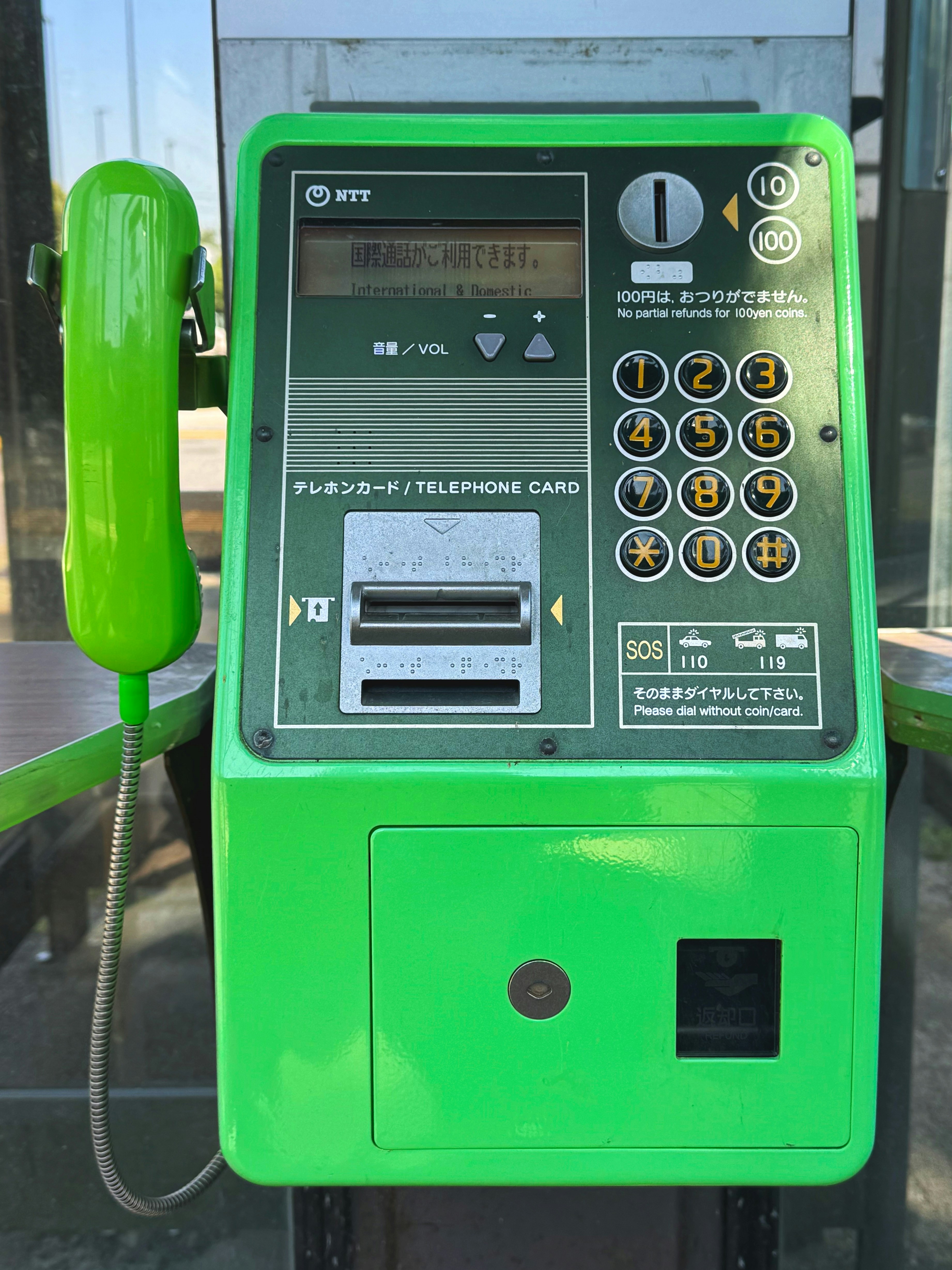 cornetta e tastiera di un telefono pubblico verde