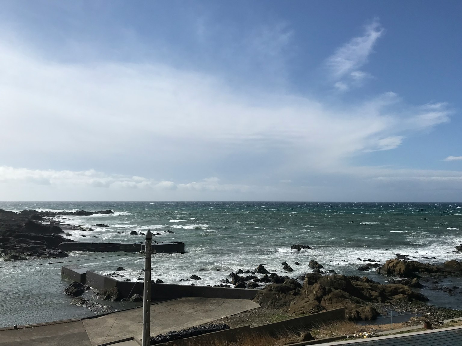 海浪拍打岩石下的蓝天