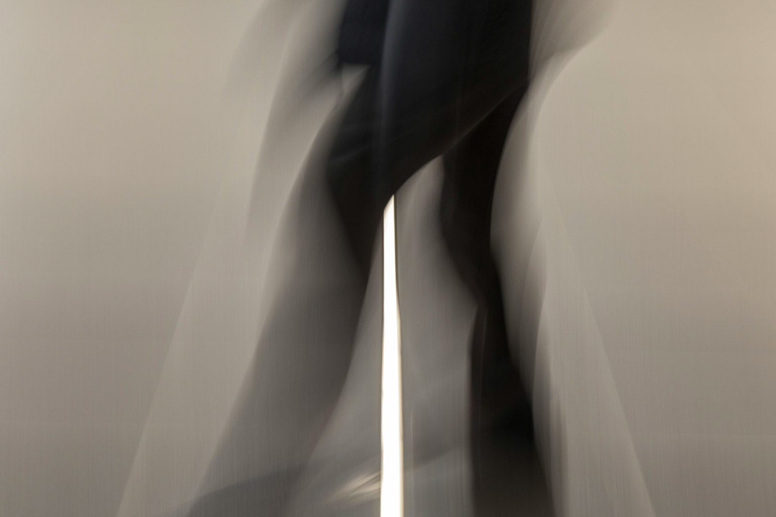 Blurred silhouette of a moving person with a striking white line