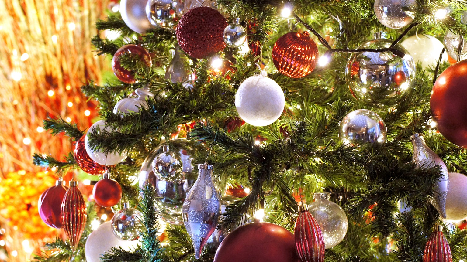 Cây thông Noel trang trí bằng đồ trang trí màu đỏ và trắng cùng đèn sáng