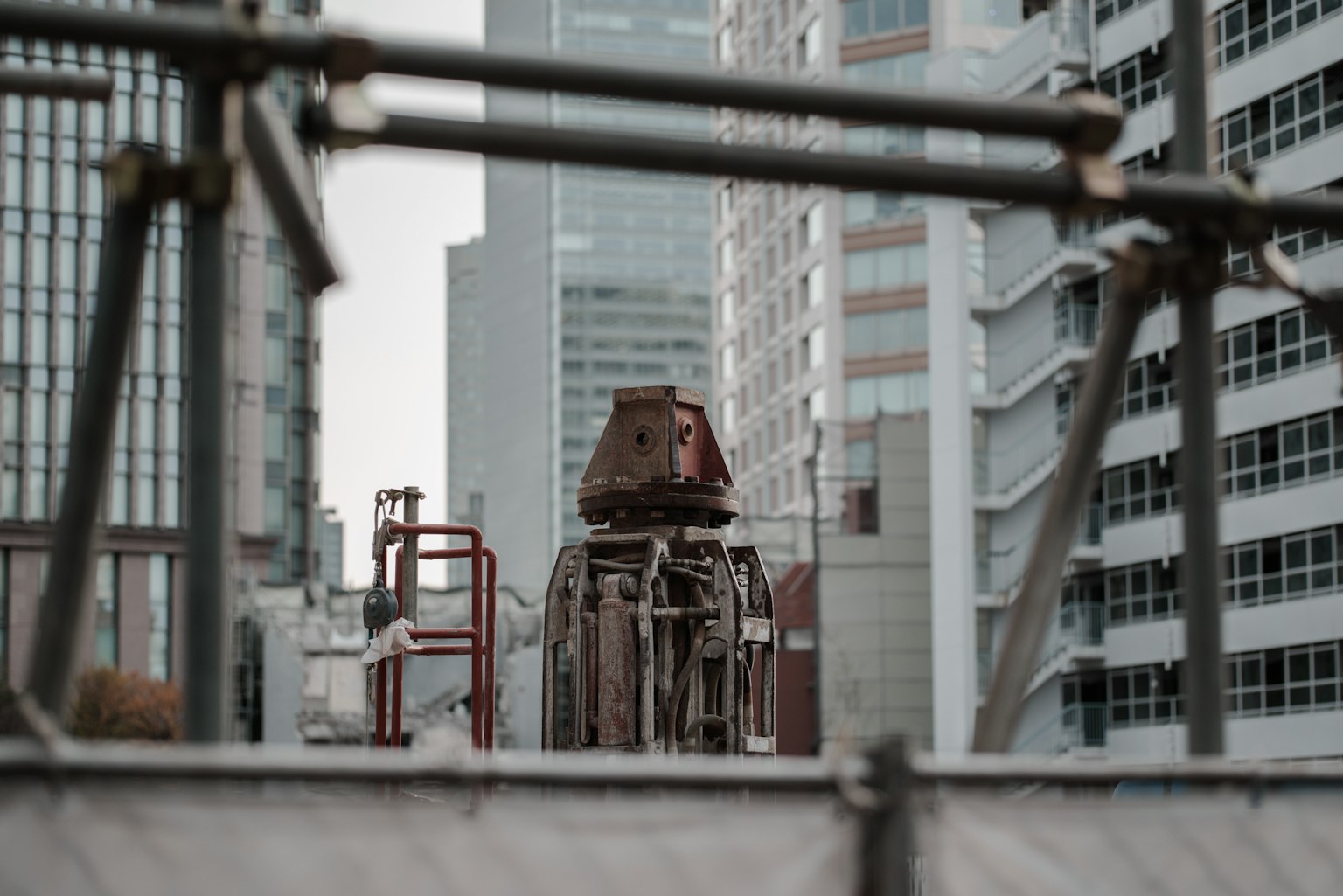 Gros plan sur une machine de construction entre des bâtiments
