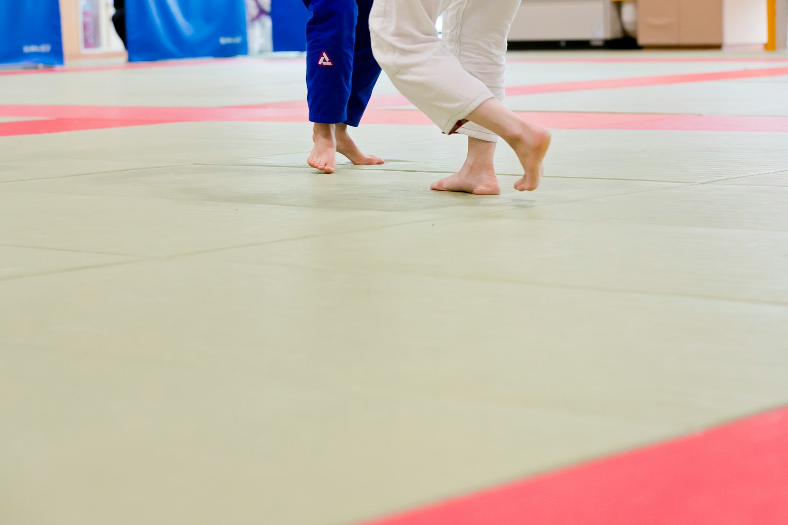 Primo piano dei piedi di due atleti su un tappeto da judo