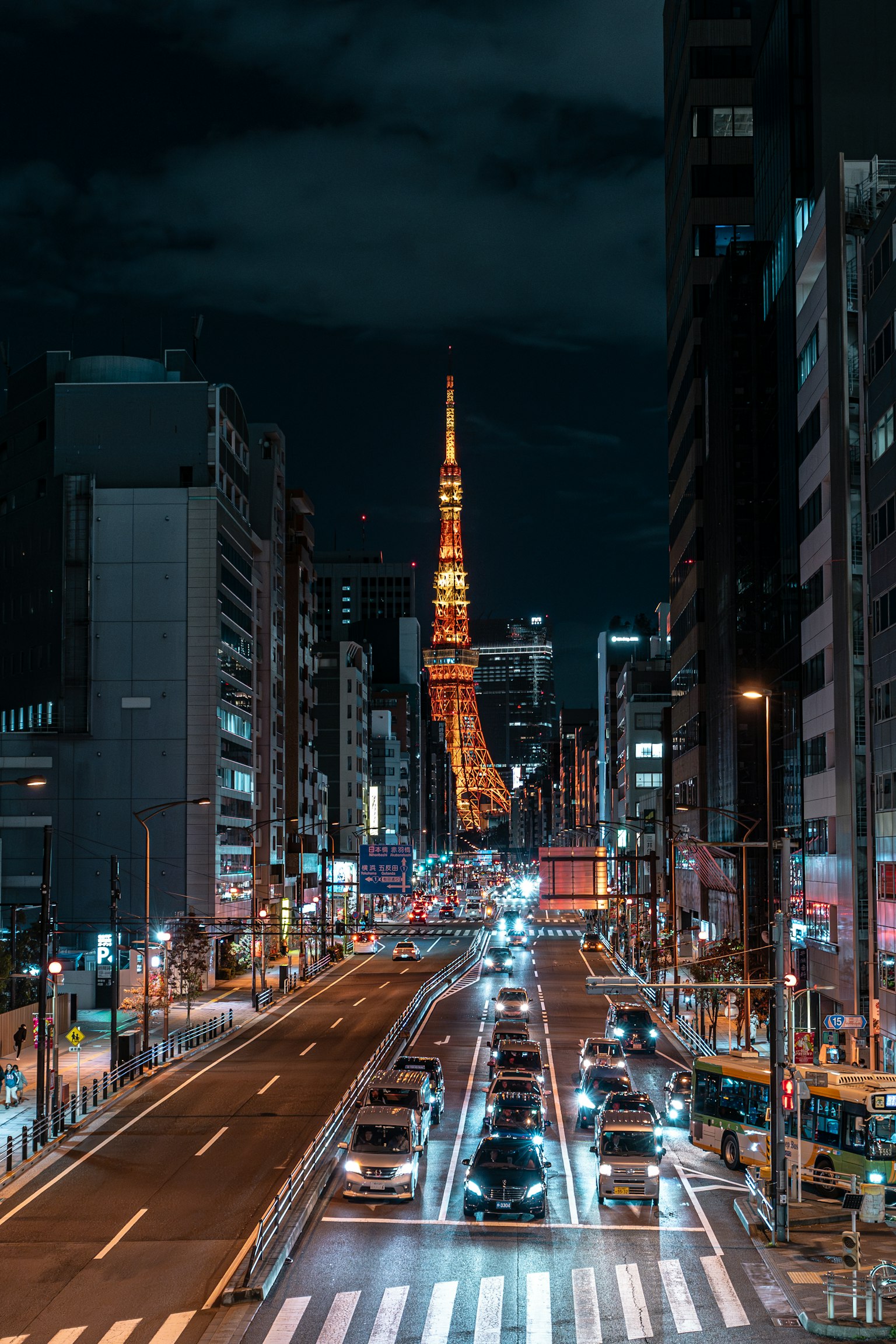 Menara Tokyo yang diterangi di langit malam dengan lalu lintas sibuk di jalan