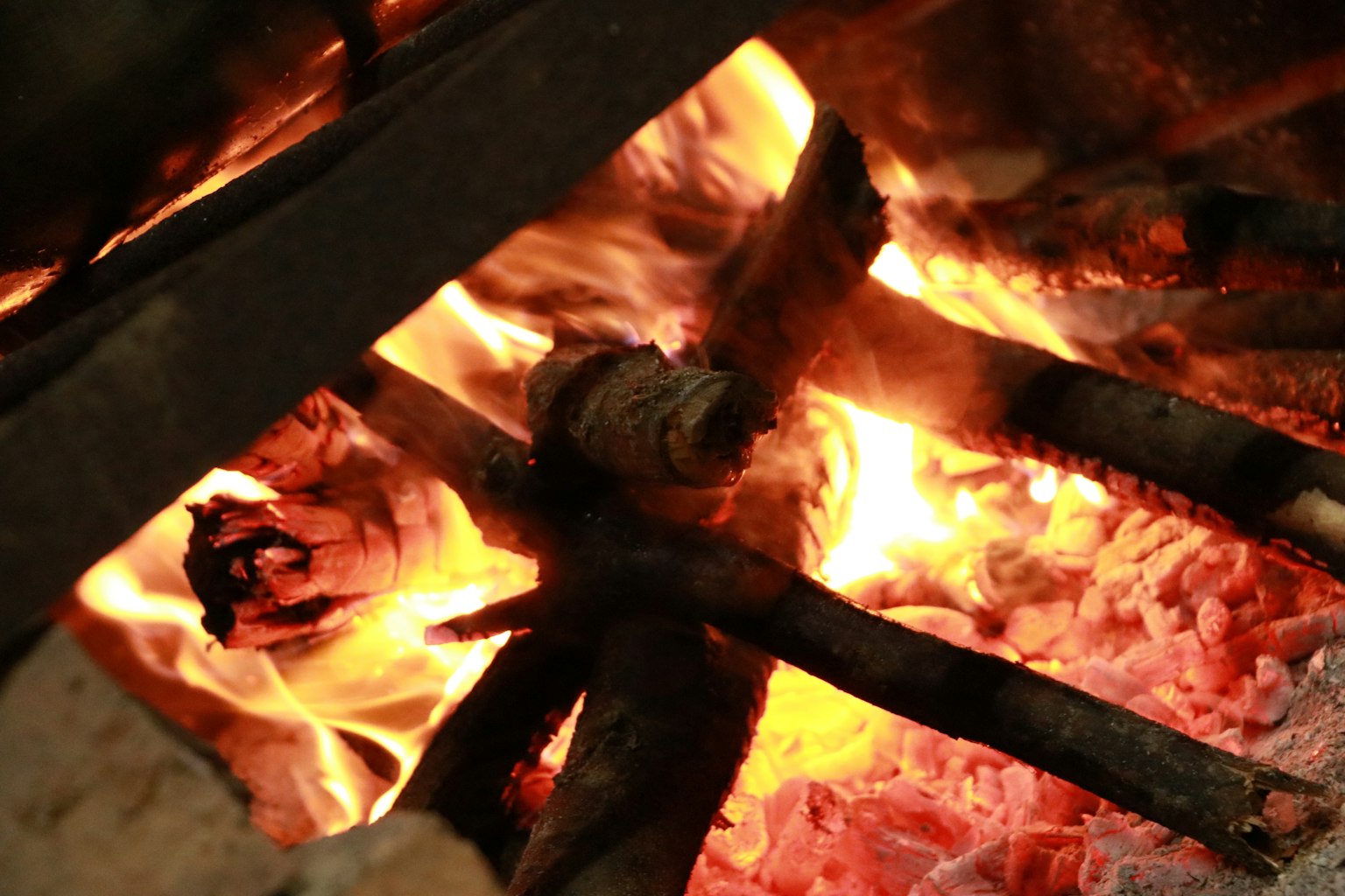 Nahaufnahme eines warmen Lagerfeuers mit Flammen und glühenden Kohlen