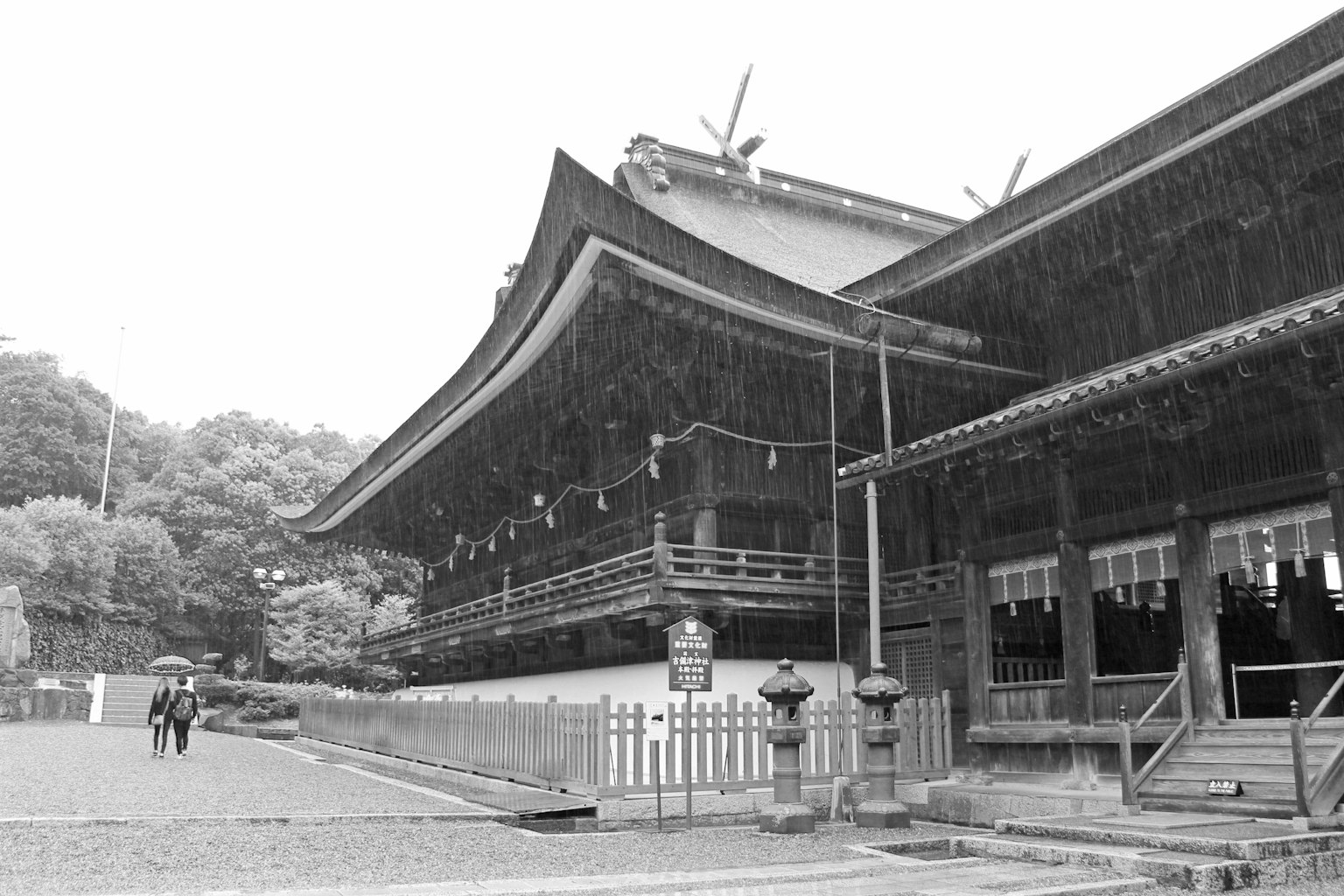 Traditional Japanese shrine building standing in the rain