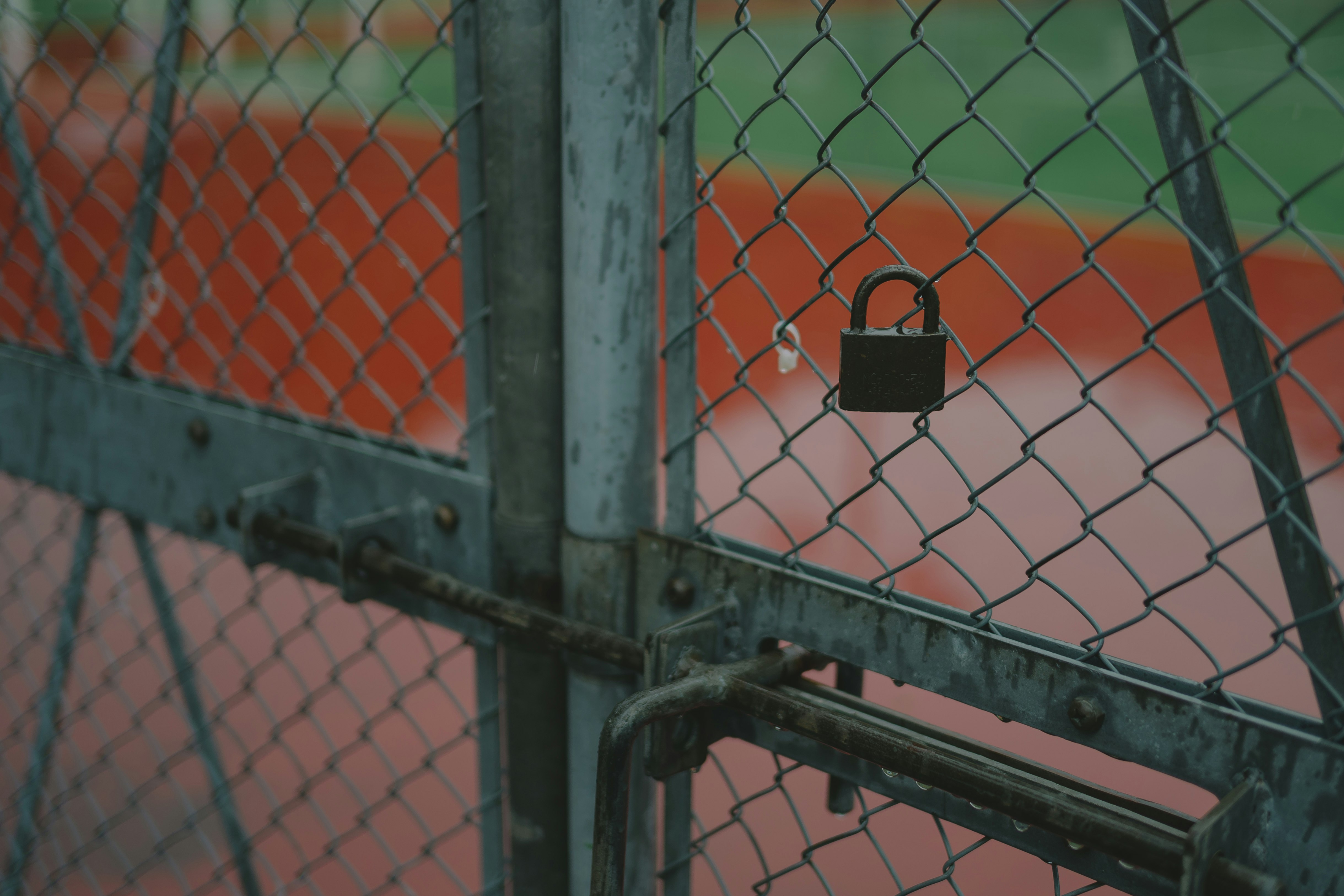Regennasses Tennisplatz-Geländer mit Netz und Spielfeld