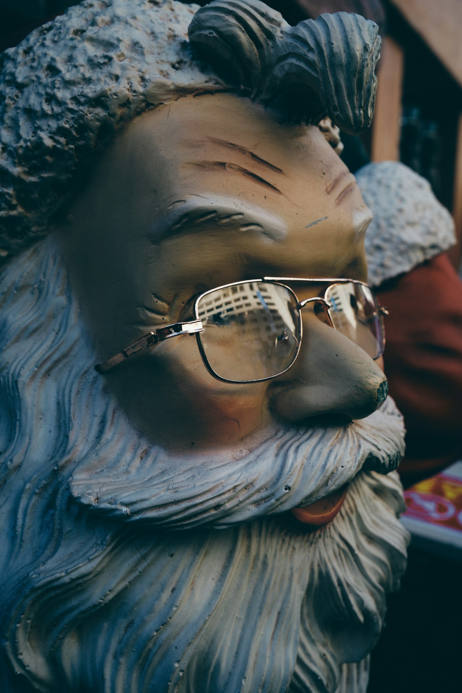 Immagine ravvicinata di una scultura di Babbo Natale con occhiali e barba bianca