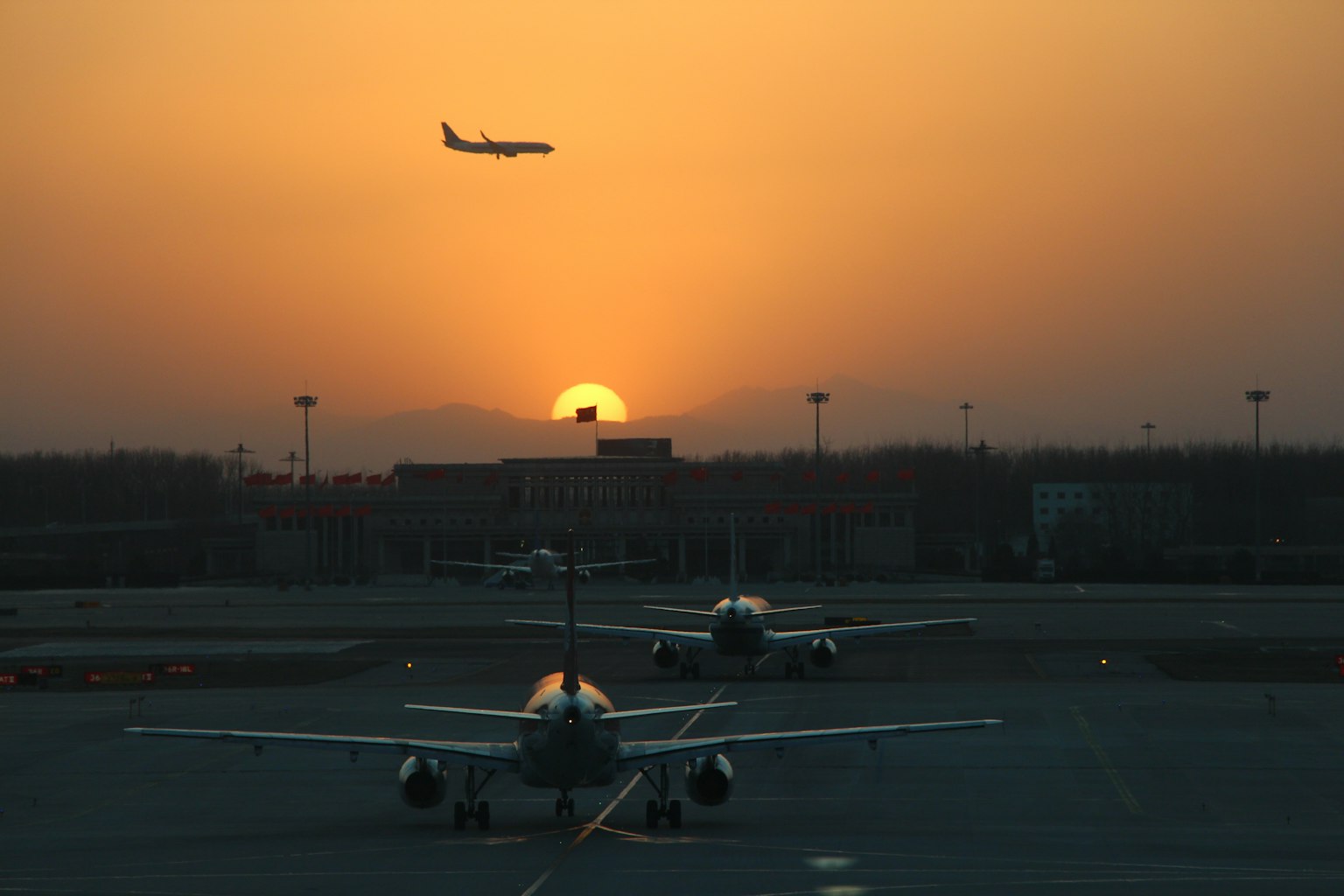 해질녘 배경의 공항 장면과 활주로에 있는 비행기들