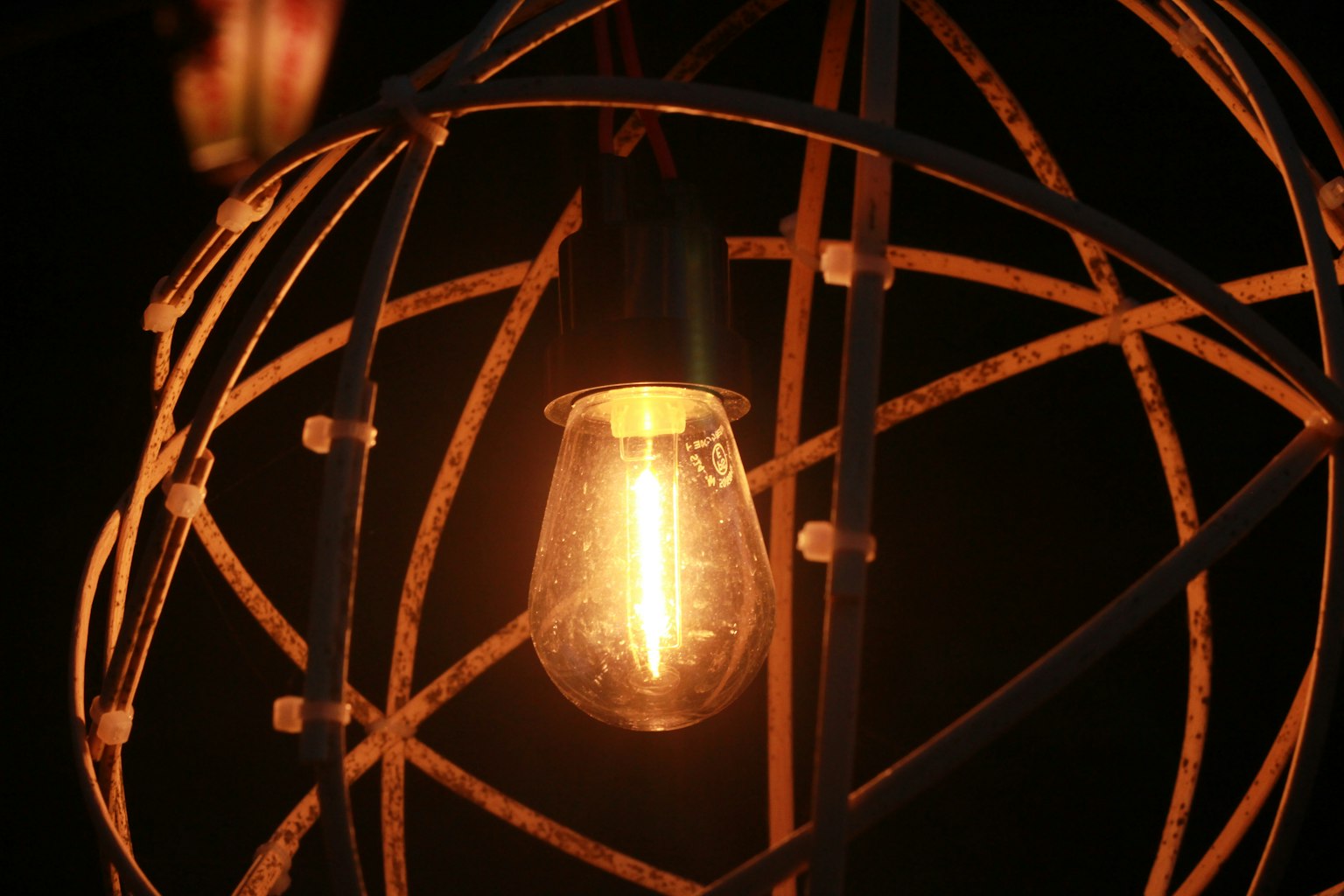 A glowing light bulb surrounded by a decorative metal frame