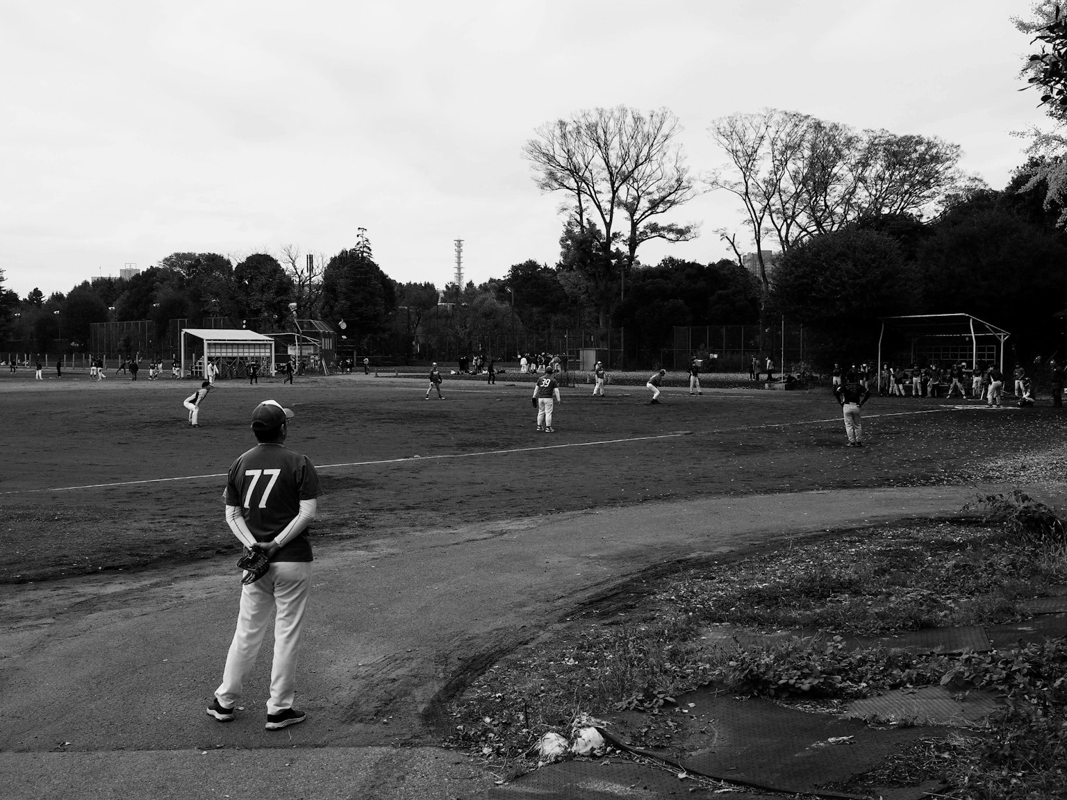 Joueurs sur un terrain de baseball avec un spectateur au premier plan