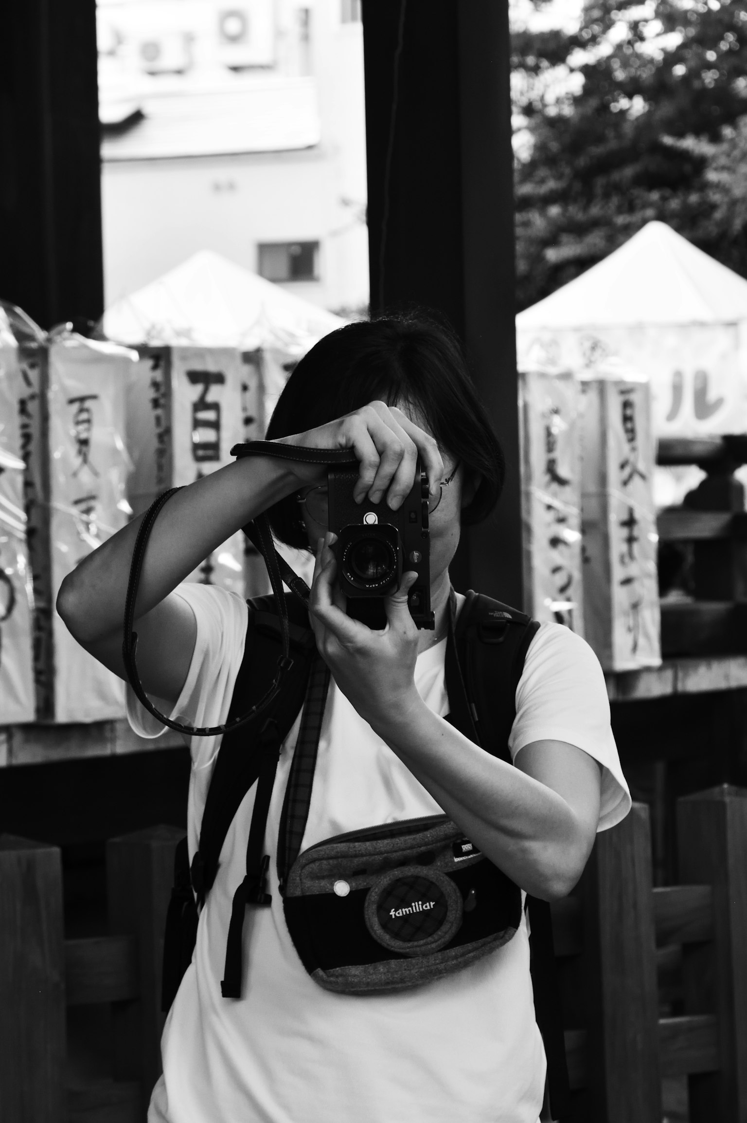 Una mujer tomando una foto con una cámara en blanco y negro