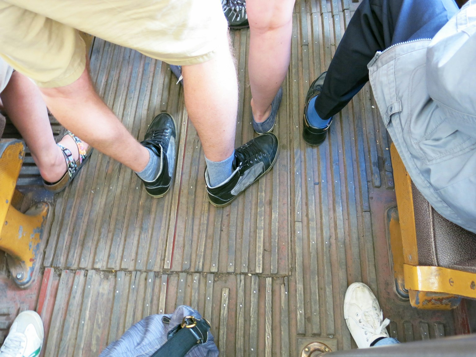 Vista delle gambe e delle scarpe delle persone sul pavimento di un autobus