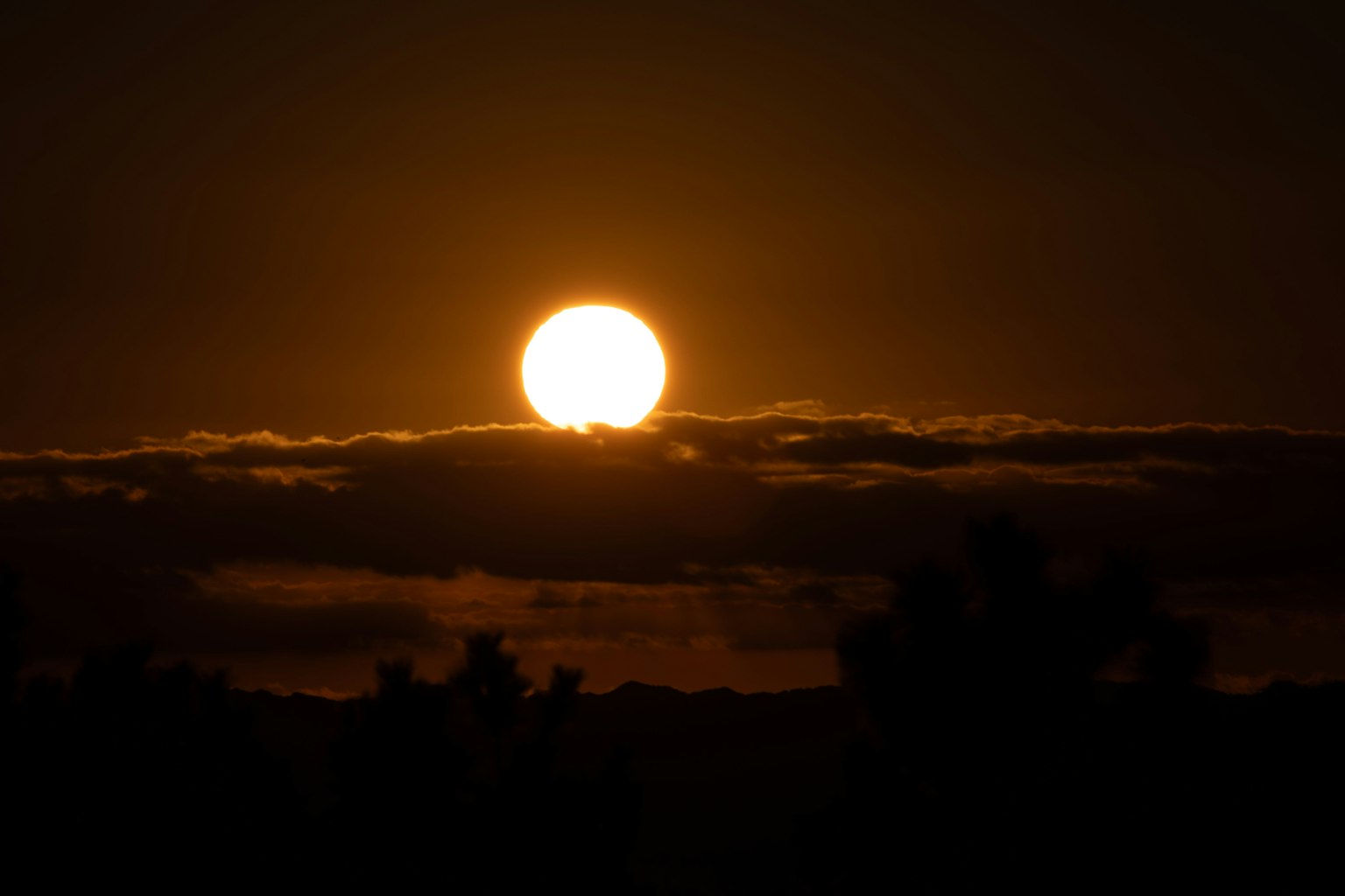 A beautiful sunset with the sun rising above the clouds