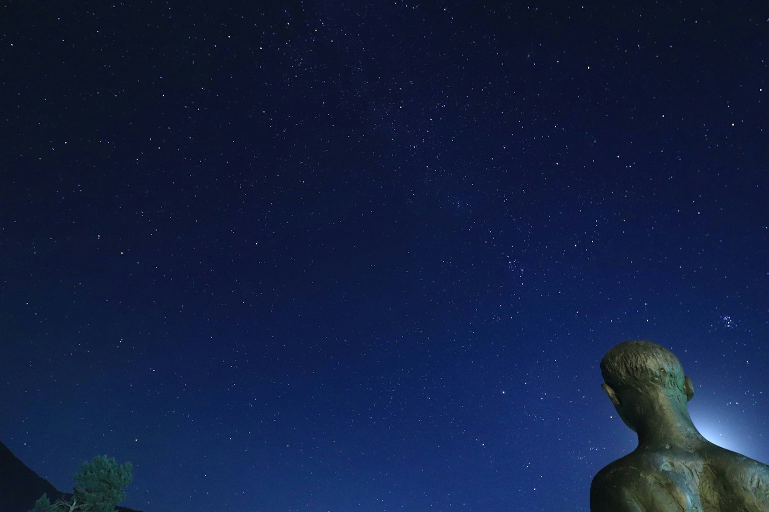 Silhouette d'une statue sous un ciel étoilé