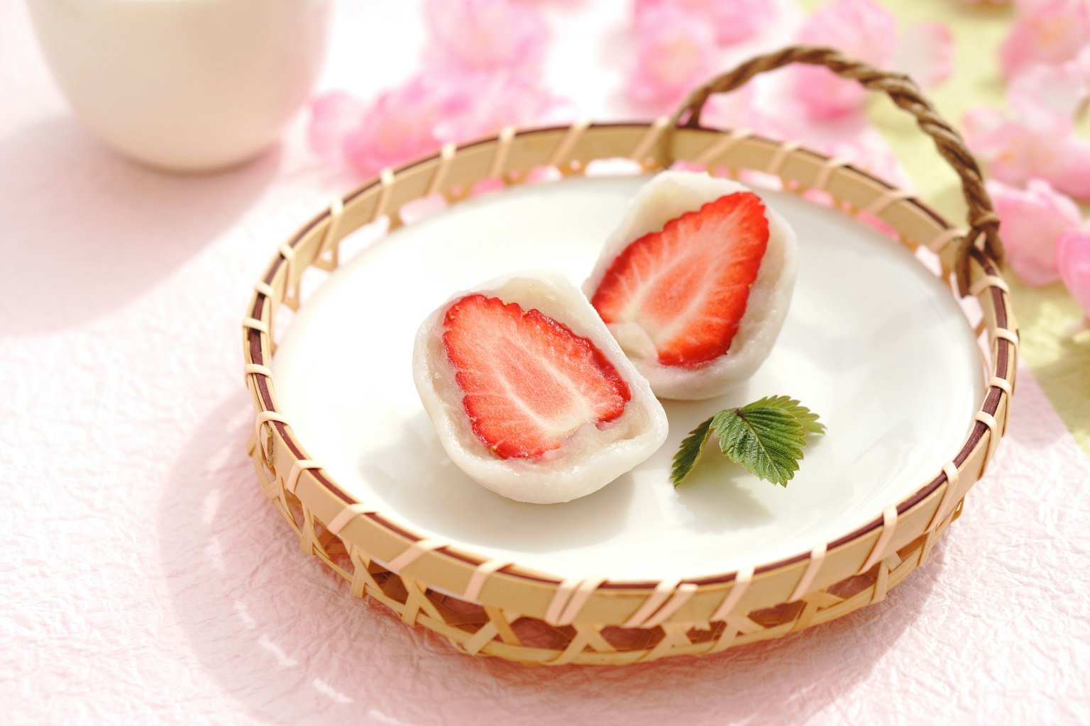 Erdbeer-Daifuku auf einem weißen Teller mit dekorativem Hintergrund präsentiert