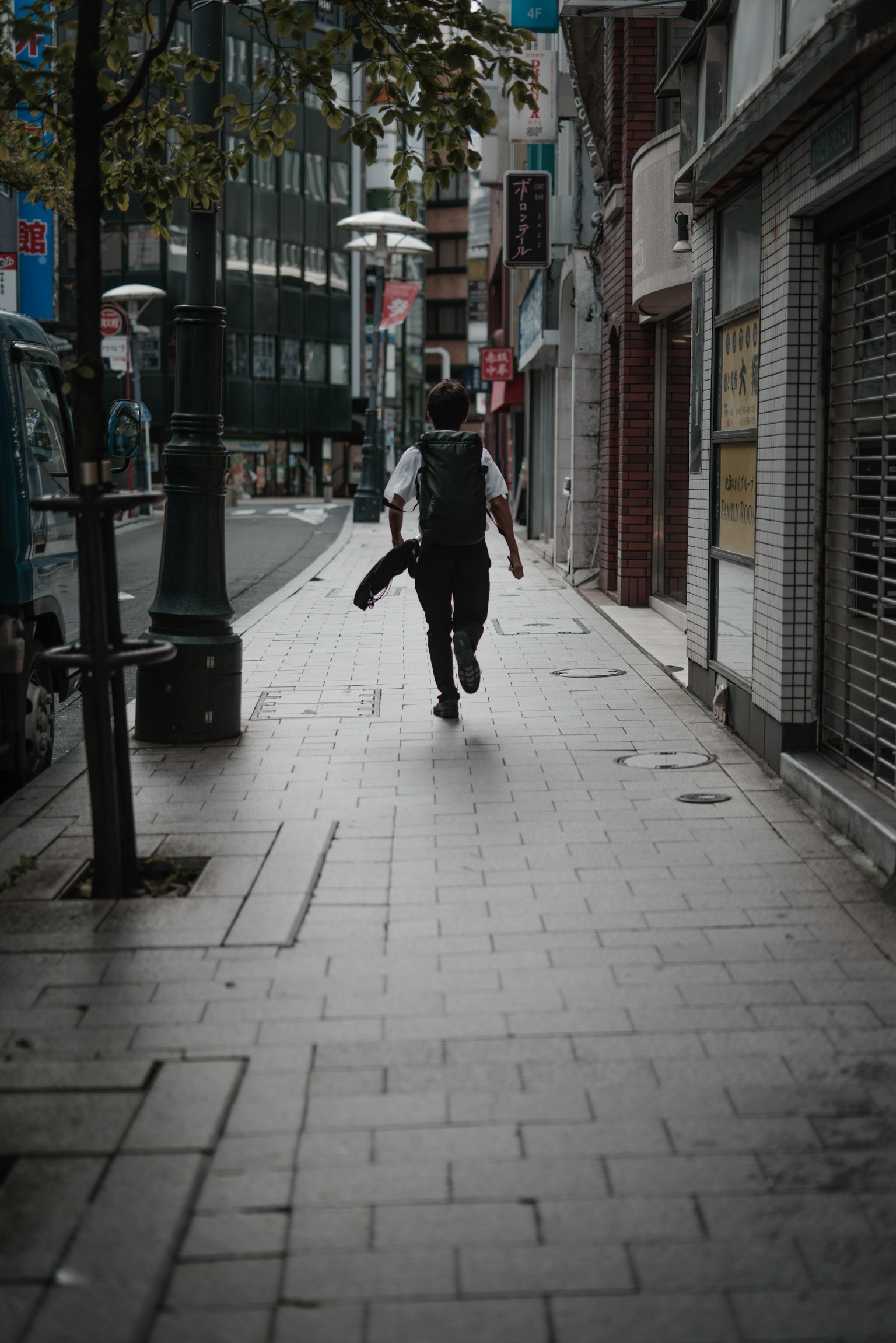 A person walking down a quiet street lined with buildings