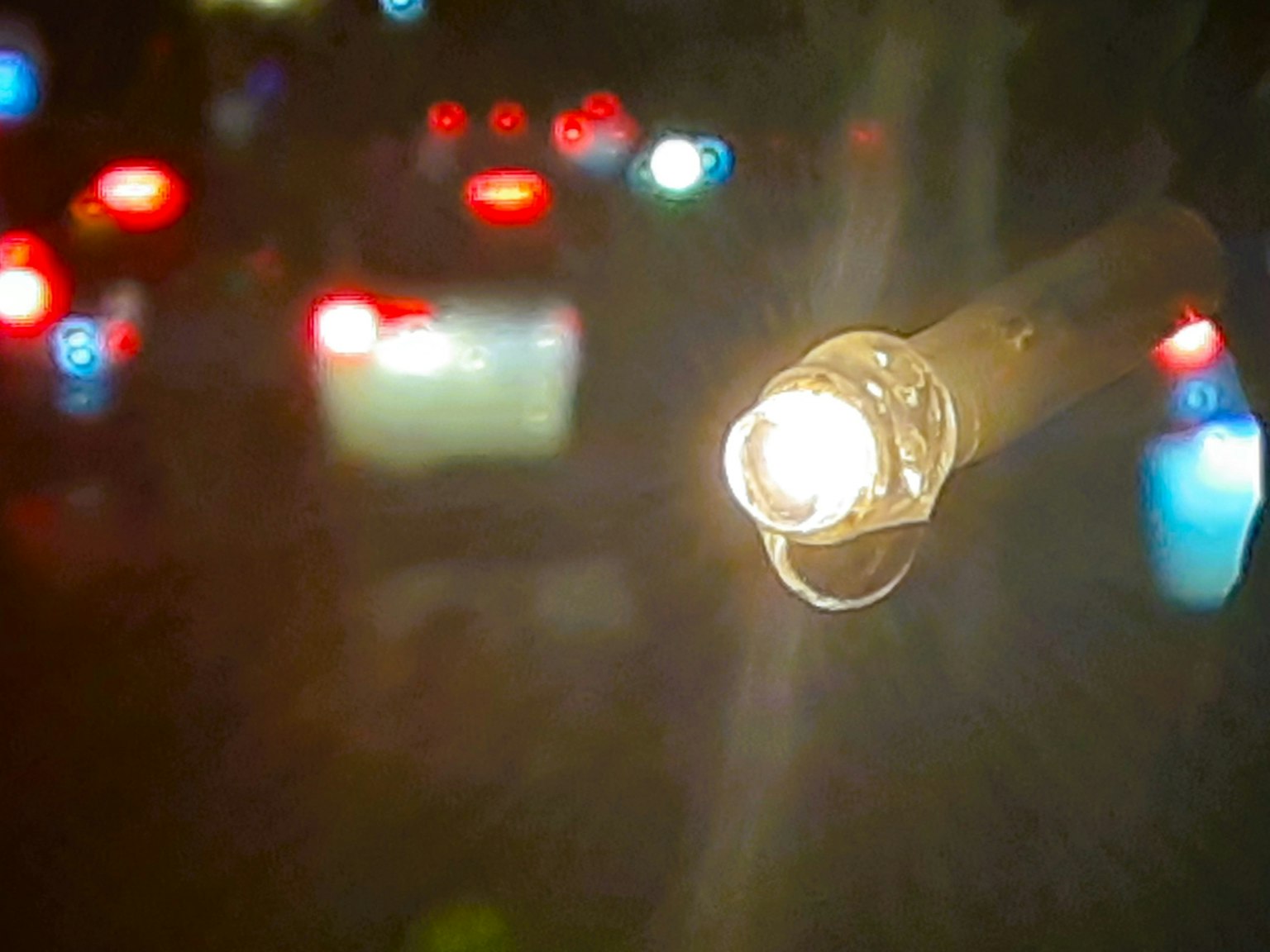前景中的明亮燈光，背景是模糊的城市燈光，夜晚