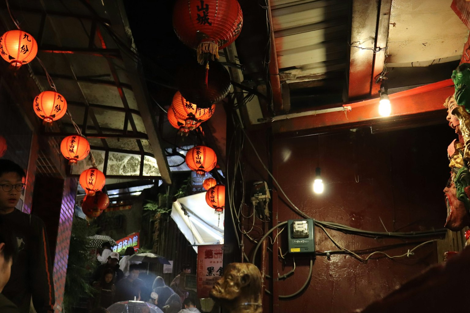 Narrow passageway with red lanterns hanging overhead