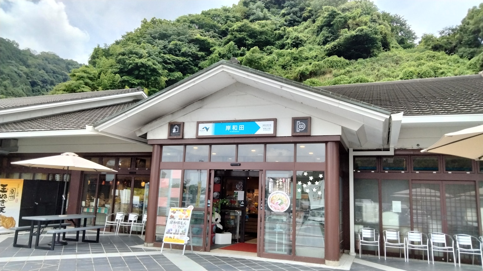 Bangunan Jepang tradisional dikelilingi oleh vegetasi dengan tanda