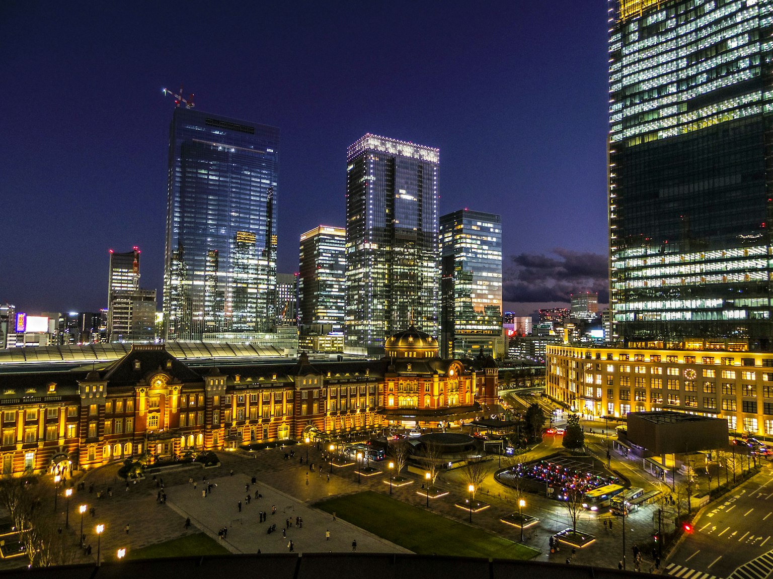 Vista notturna della stazione di Tokyo con grattacieli sullo sfondo