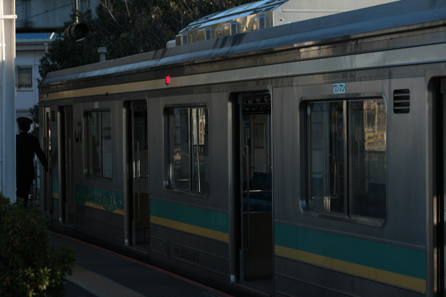 Train at a station with evening lighting and visible side features
