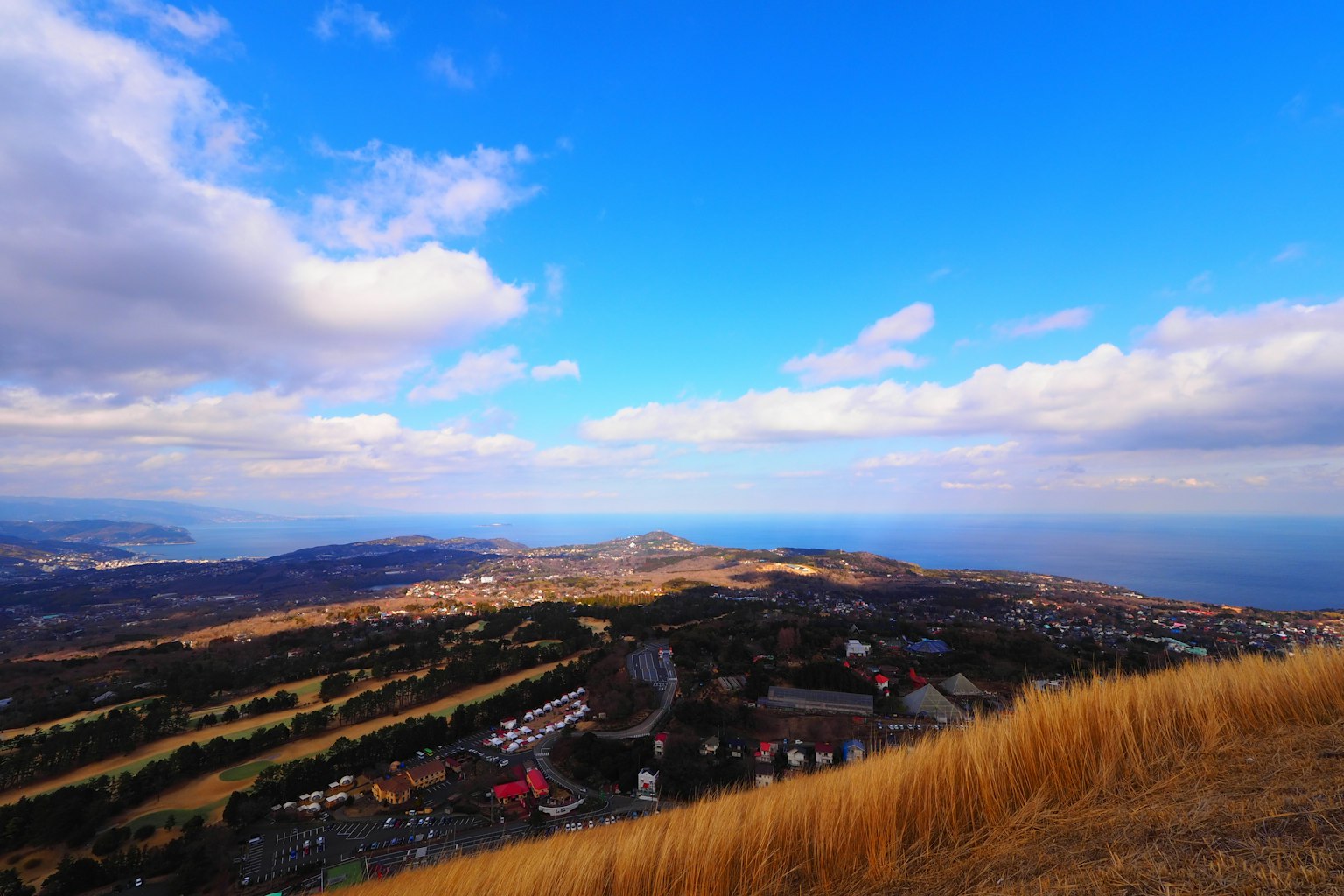 Vista panoramica dalla cima di una montagna con cielo blu nuvole e paesaggio costiero