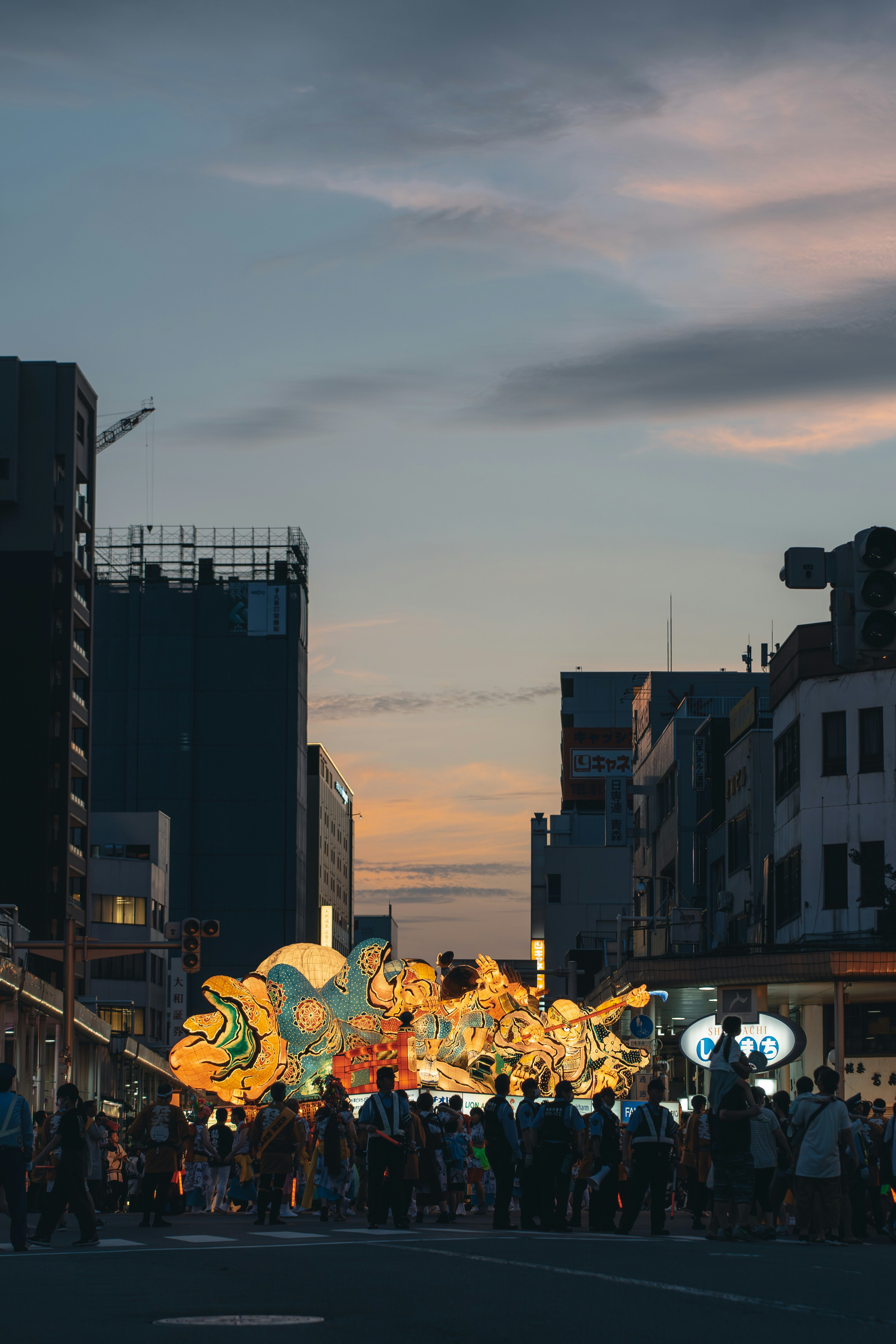 Đoàn xe diễu hành Nebuta và hàng đèn lồng trên con phố đô thị lúc hoàng hôn