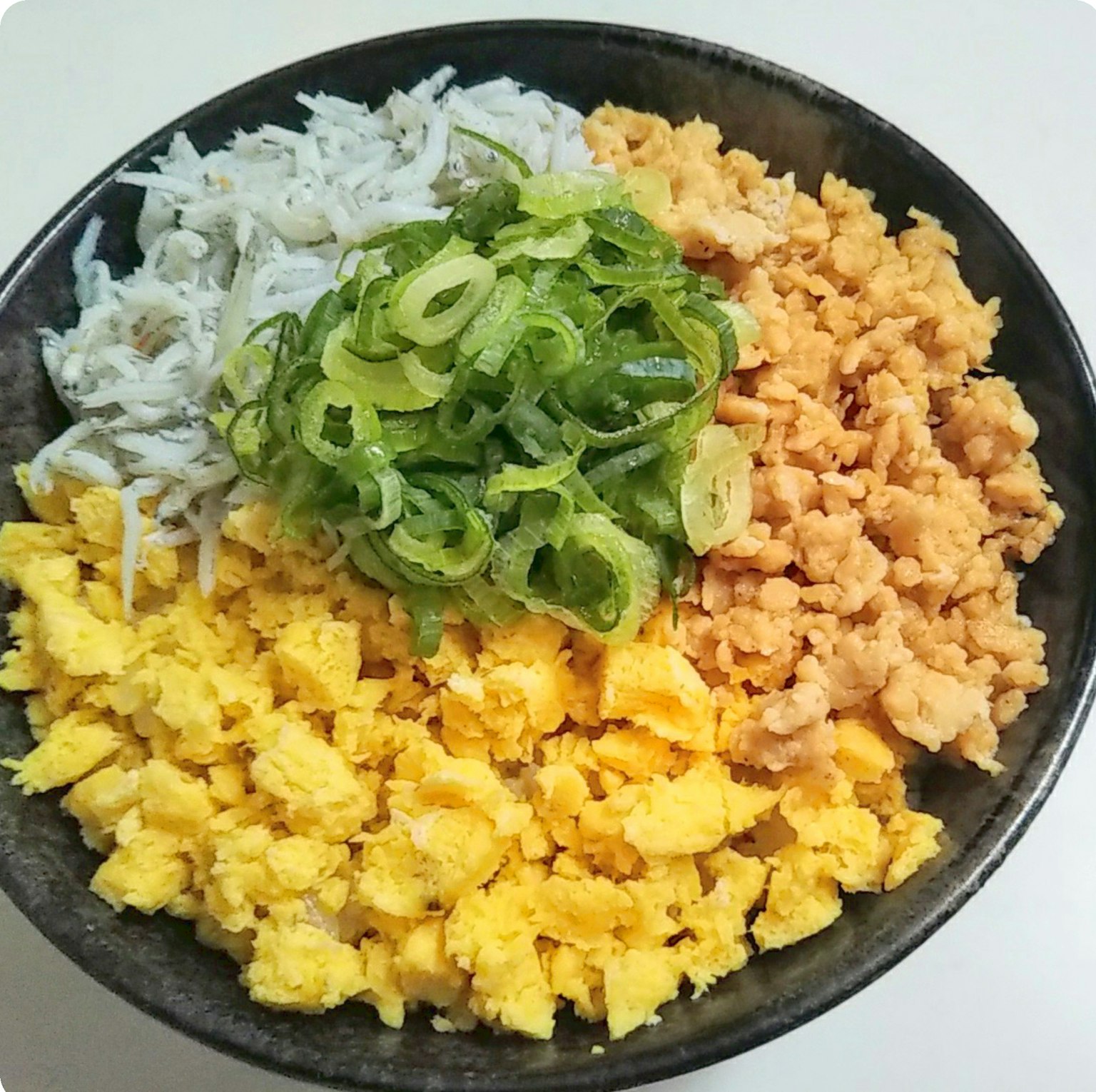 Composizione colorata di piatto con pesce bianco grattugiato uovo giallo cipollotti verdi e ingredienti arancioni