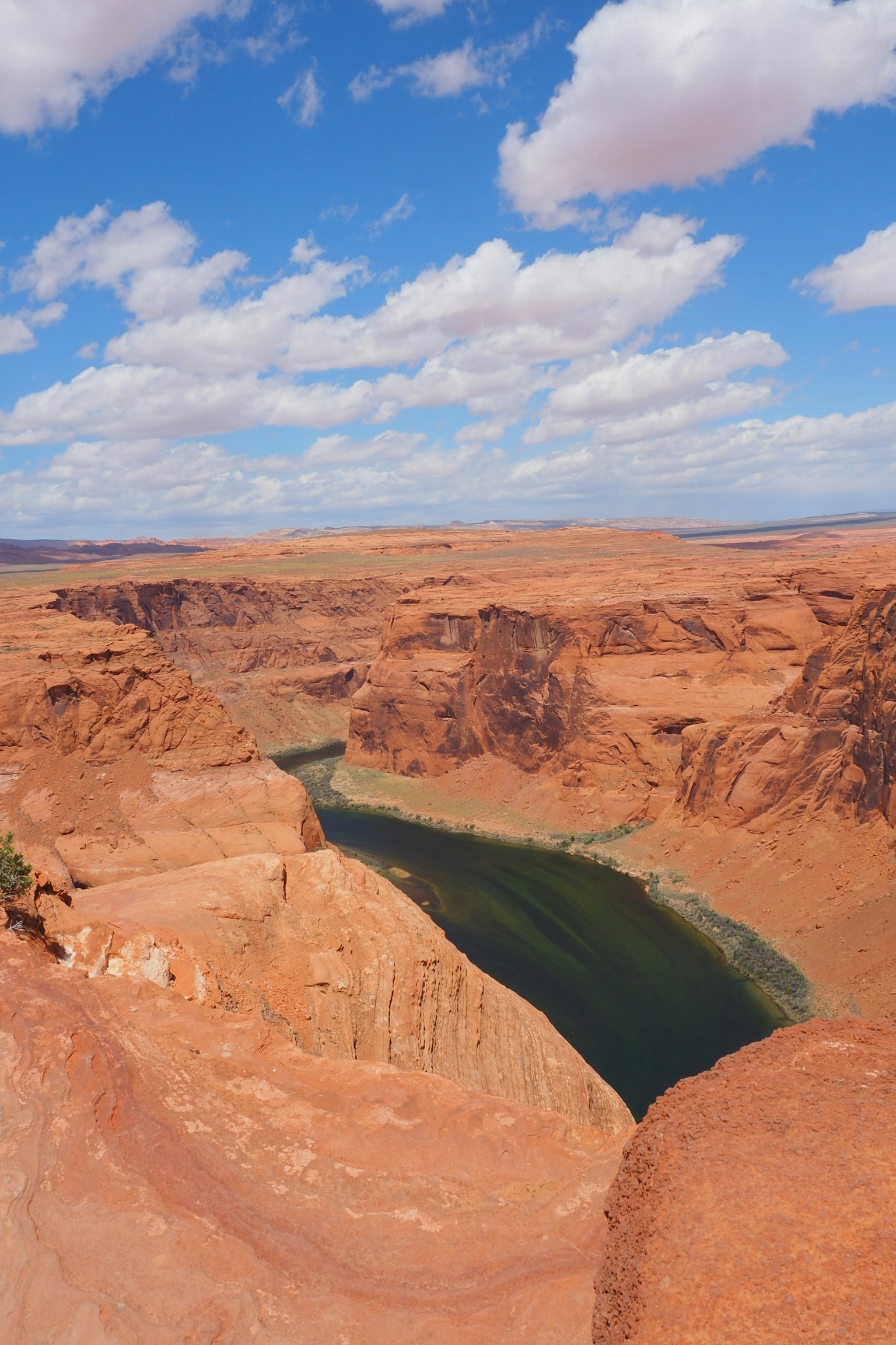 Malersiche Aussicht auf rote Felsen und blauen Himmel mit Horseshoe Bend und grünem Fluss