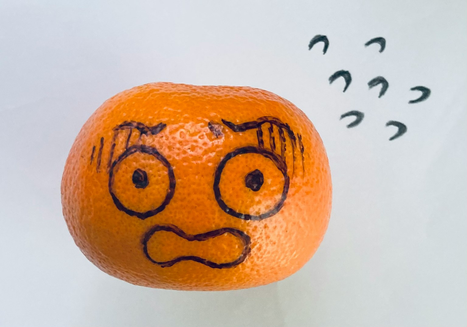 Một quả quýt với khuôn mặt ngạc nhiên được vẽ trên đó