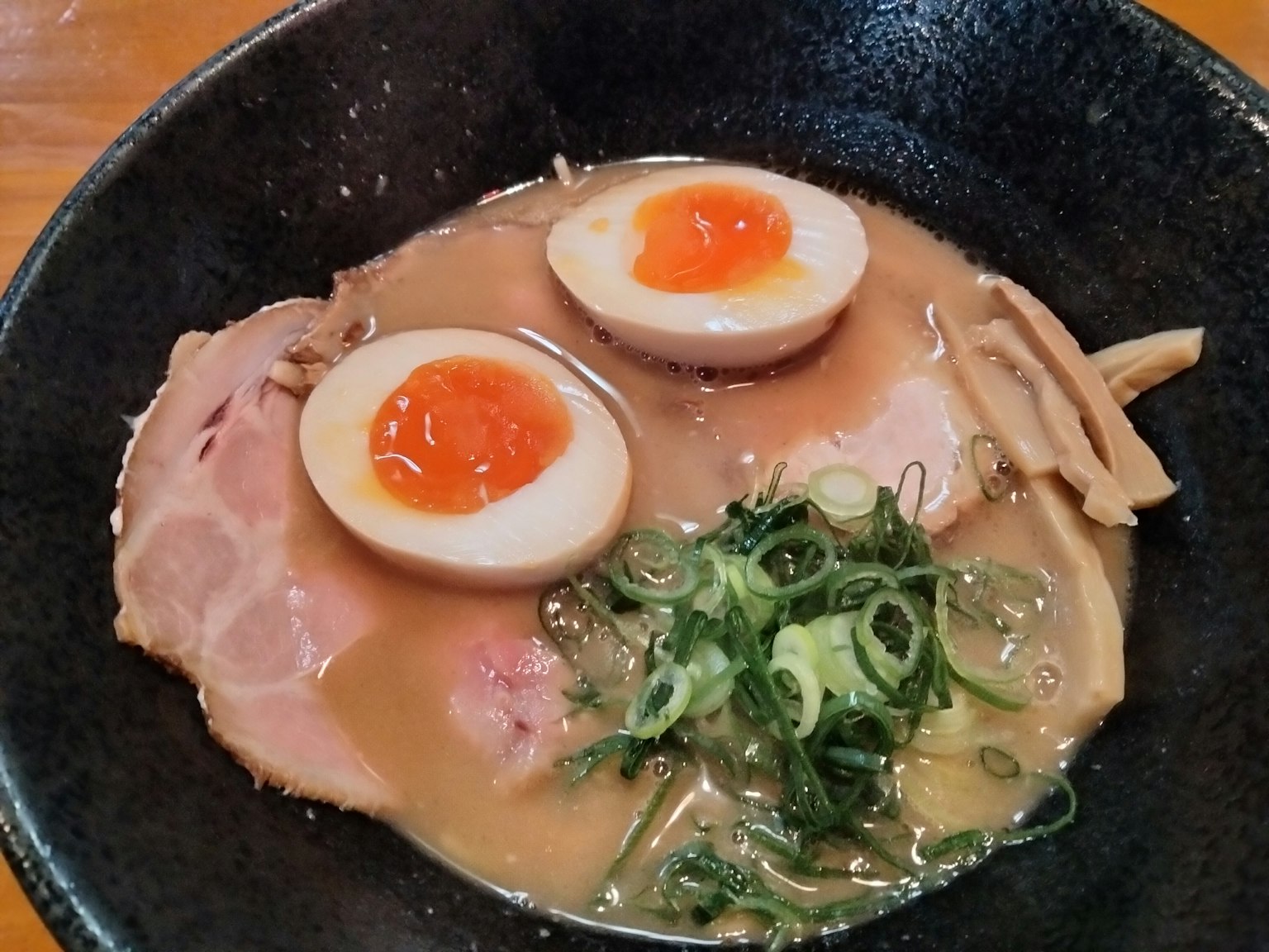 ชามราเมนที่มีหมูหั่น, ไข่ต้มยางมะตูม, และต้นหอม