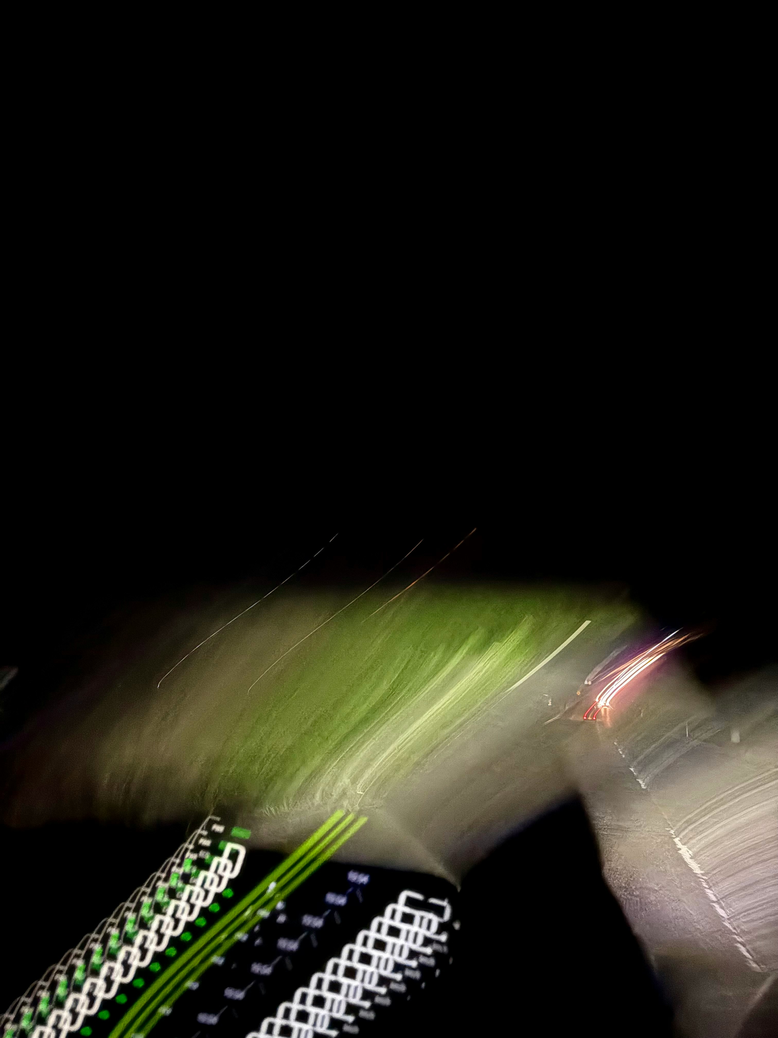 夜の道路で光が流れる車のメーター周辺の人工物と信号機