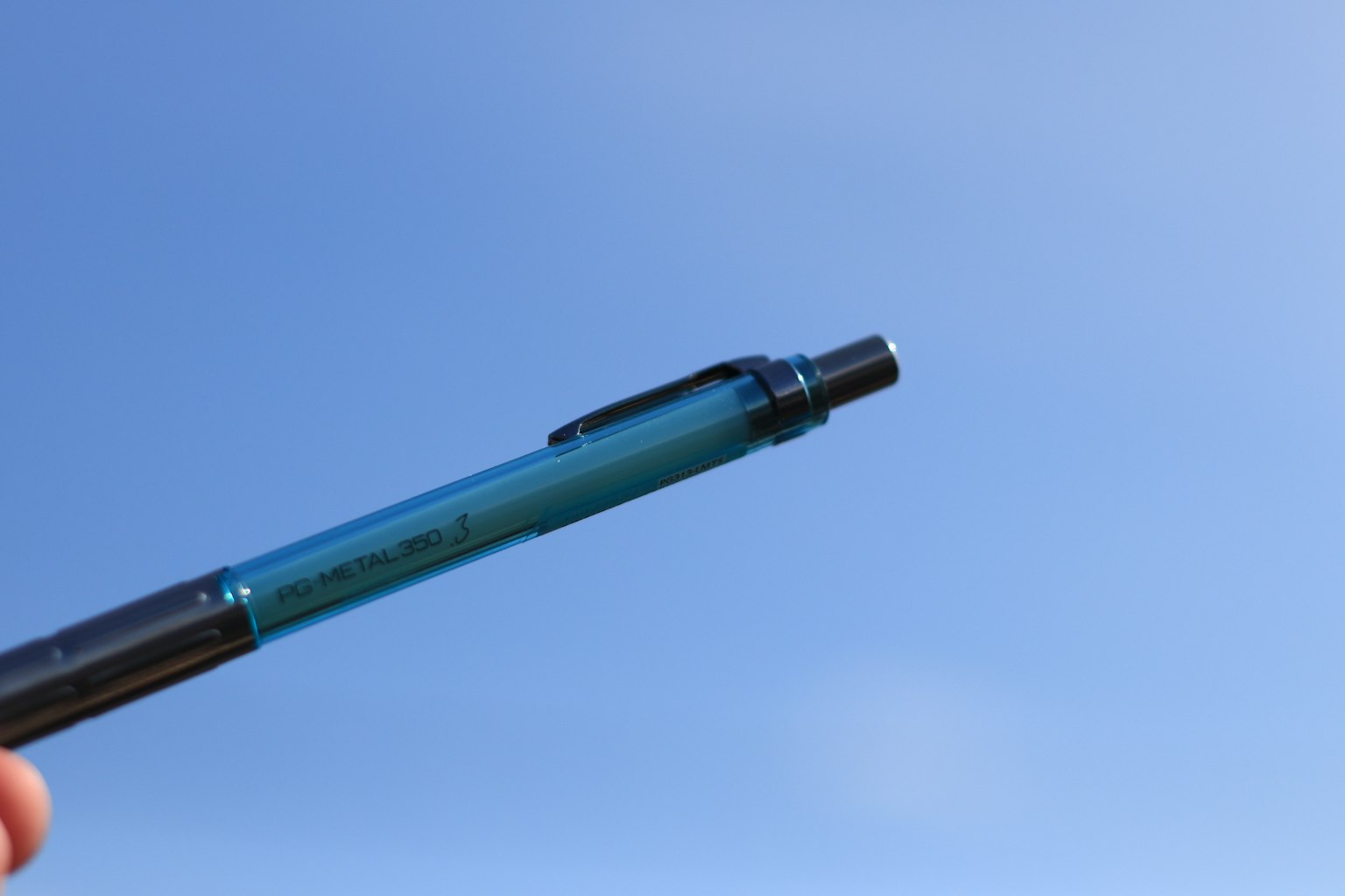 Una penna a sfera blu che punta verso il cielo blu